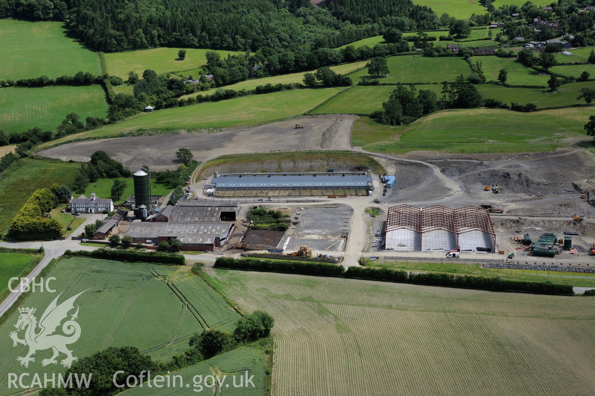 Lower Leighton farmhouse and the new 'super dairy' under construction at Lower Leighton Farm, Leighton, Welshpool. Oblique aerial photograph taken during the Royal Commission's programme of archaeological aerial reconnaissance by Toby Driver on 30th June 2015.
