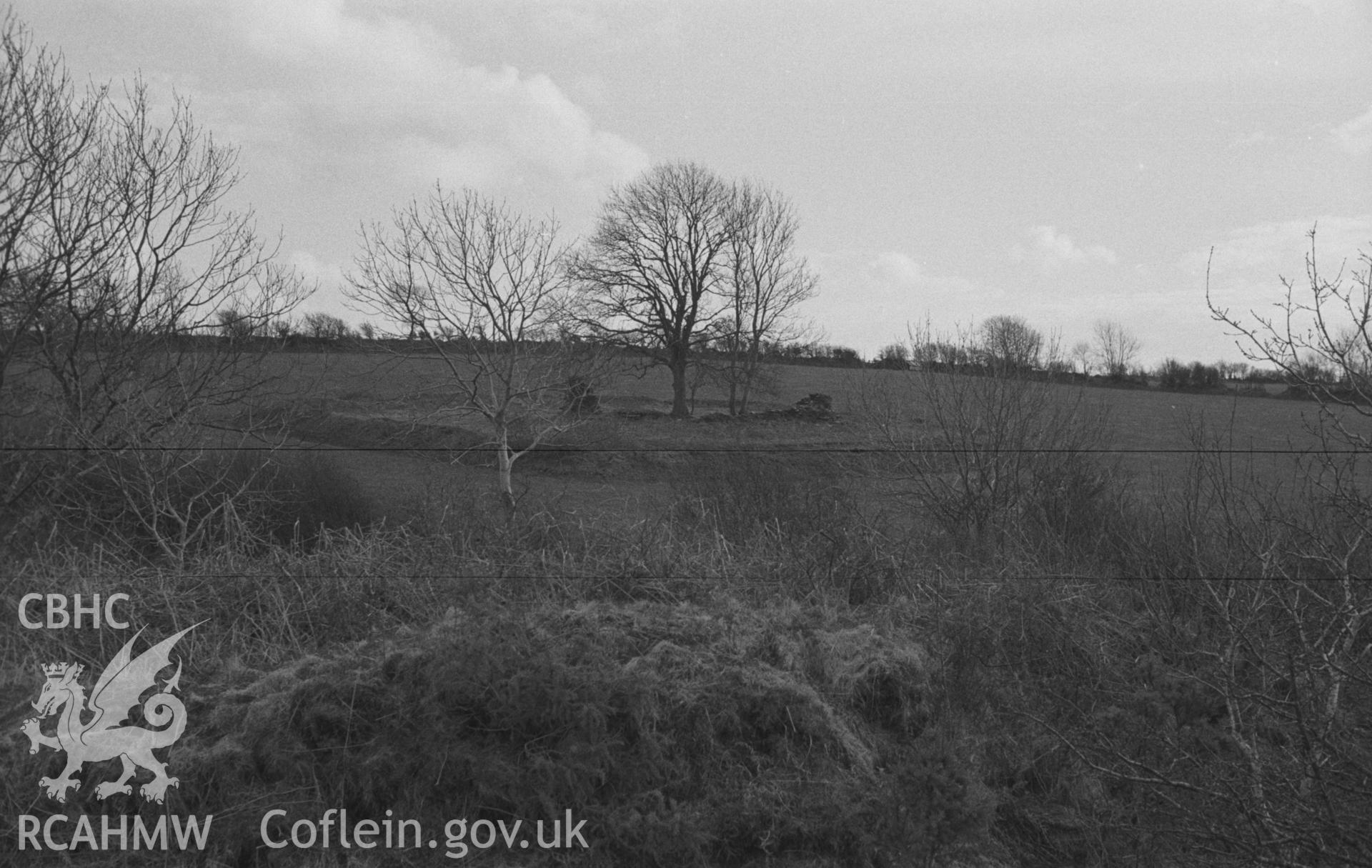 Digital copy of a black and white negative showing site of St Mary's church from the top of the Norman motte near Llanfair Trefhelygen. Photographed in April 1963 by Arthur O. Chater from Grid Reference SN 3442 4422, looking south west.