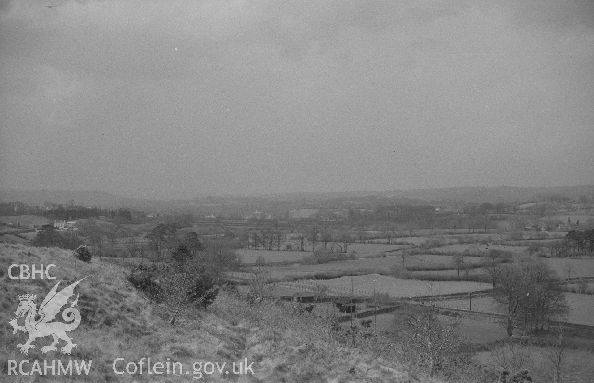 Digital copy of black & white negative showing view from outside Pencarreg churchyard towards railway line, with Llanybydder and Castell Dol-Wlff in distance. Photographed by Arthur O. Chater in April 1967 looking west south west SN 534 450.