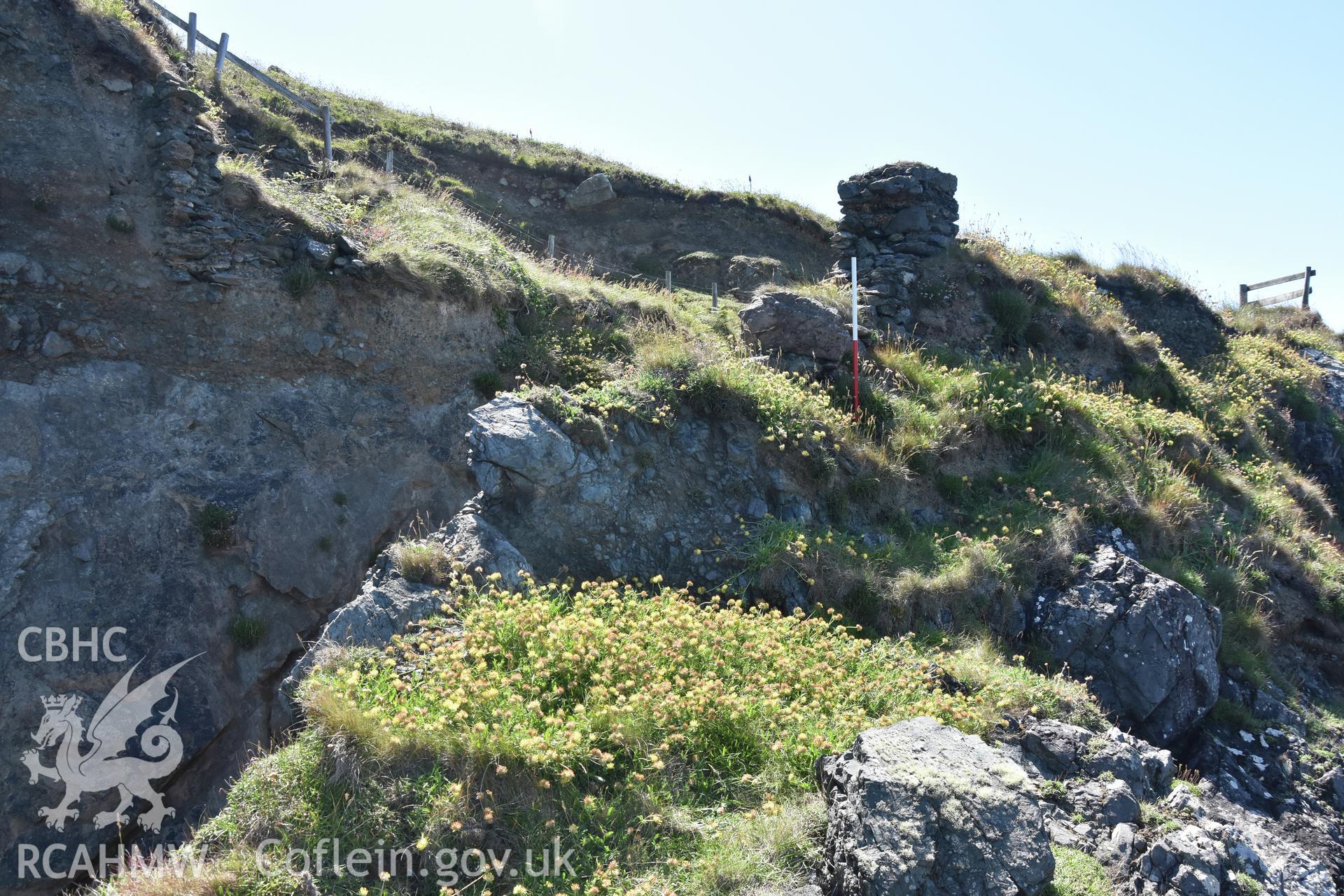 Penmaenmelyn copper mine. View from north-west of potential rock 'jetty' at north of mine, with standing masonry on coast edge and area of collapse over shafts. Investigator?s photographic survey for the CHERISH Project. ? Crown: CHERISH PROJECT 2019. Produced with EU funds through the Ireland Wales Co-operation Programme 2014-2020. All material made freely available through the Open Government Licence.