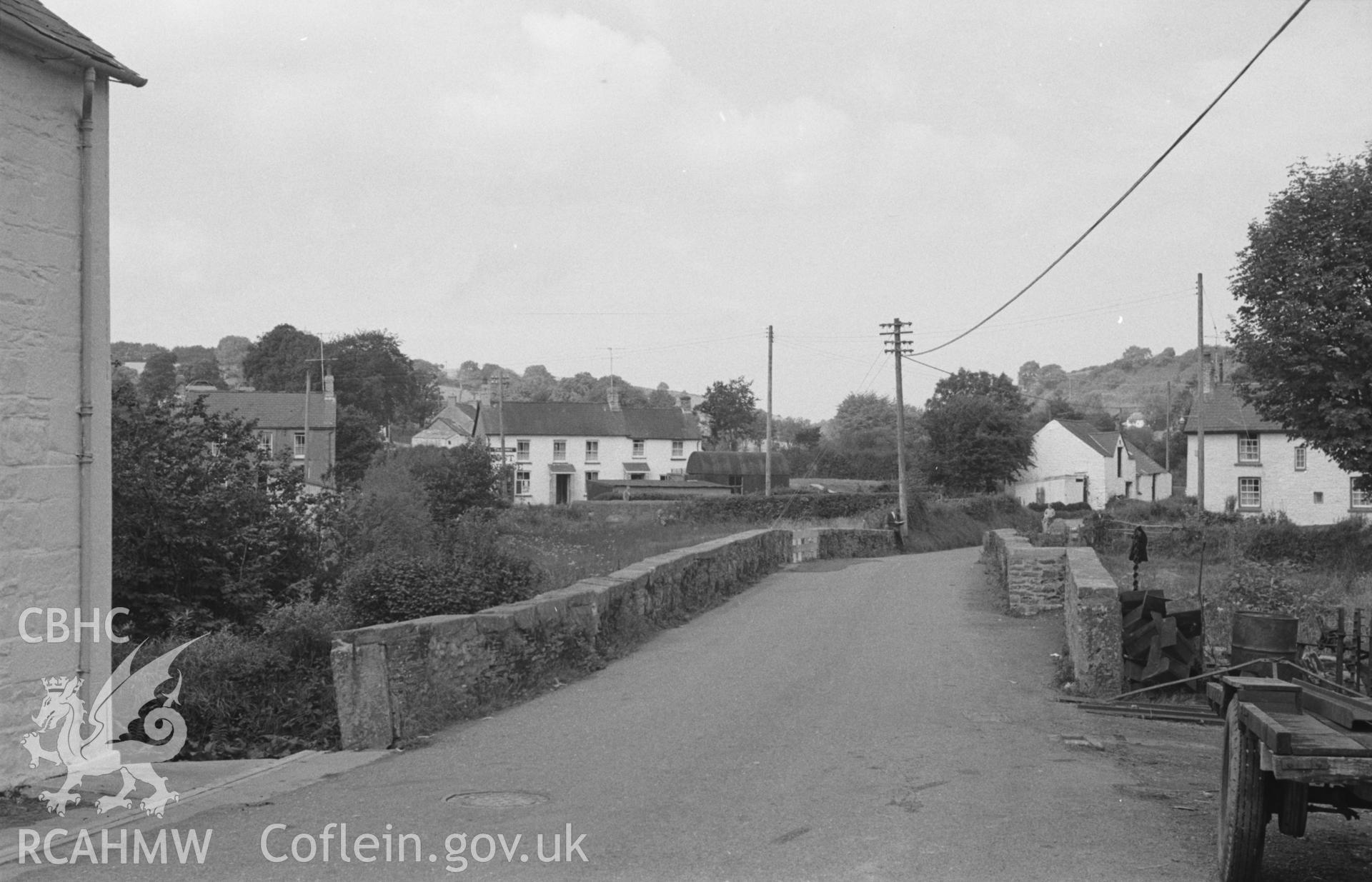 Digital copy of black & white negative showing view across the bridge over the Clettwr Fawr towards Post Office at Talgarreg. Photographed by Arthur O. Chater in August 1965 looking north west from Grid Reference SN 4256 5116. Bridge destroyed c. 1977.