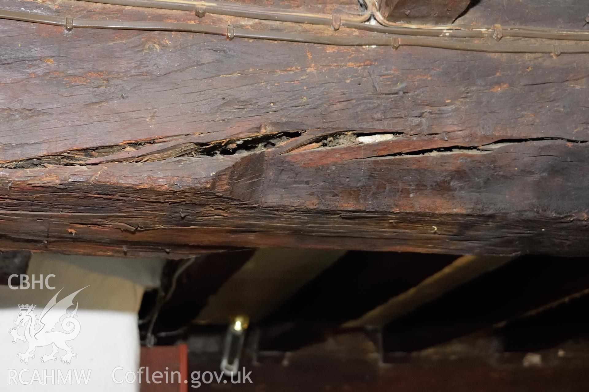 Colour photograph showing detailed view looking south at chamfer and stop on the eastern ceiling beam at Y Sospan, Llys Owain, Dolgellau. Photographed by I. P. Brookes of Engineering Archaeological Services, June 2019.