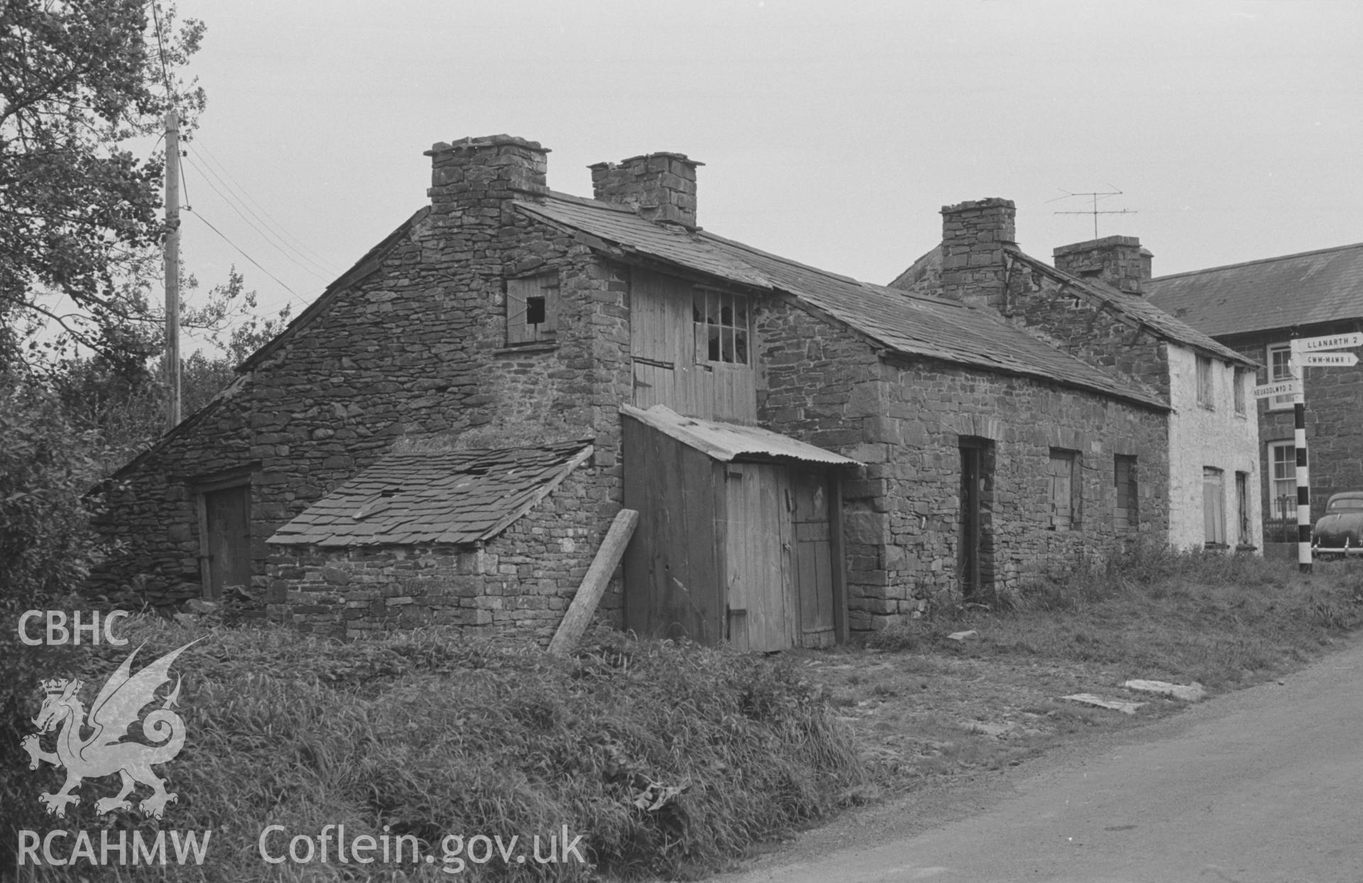 Digital copy of a black and white negative showing old buildings on the Llwyncelyn road just north west of the crossroads. Photographed by Arthur O. Chater on 5th September 1966 looking east from Grid Reference SN 452 581.