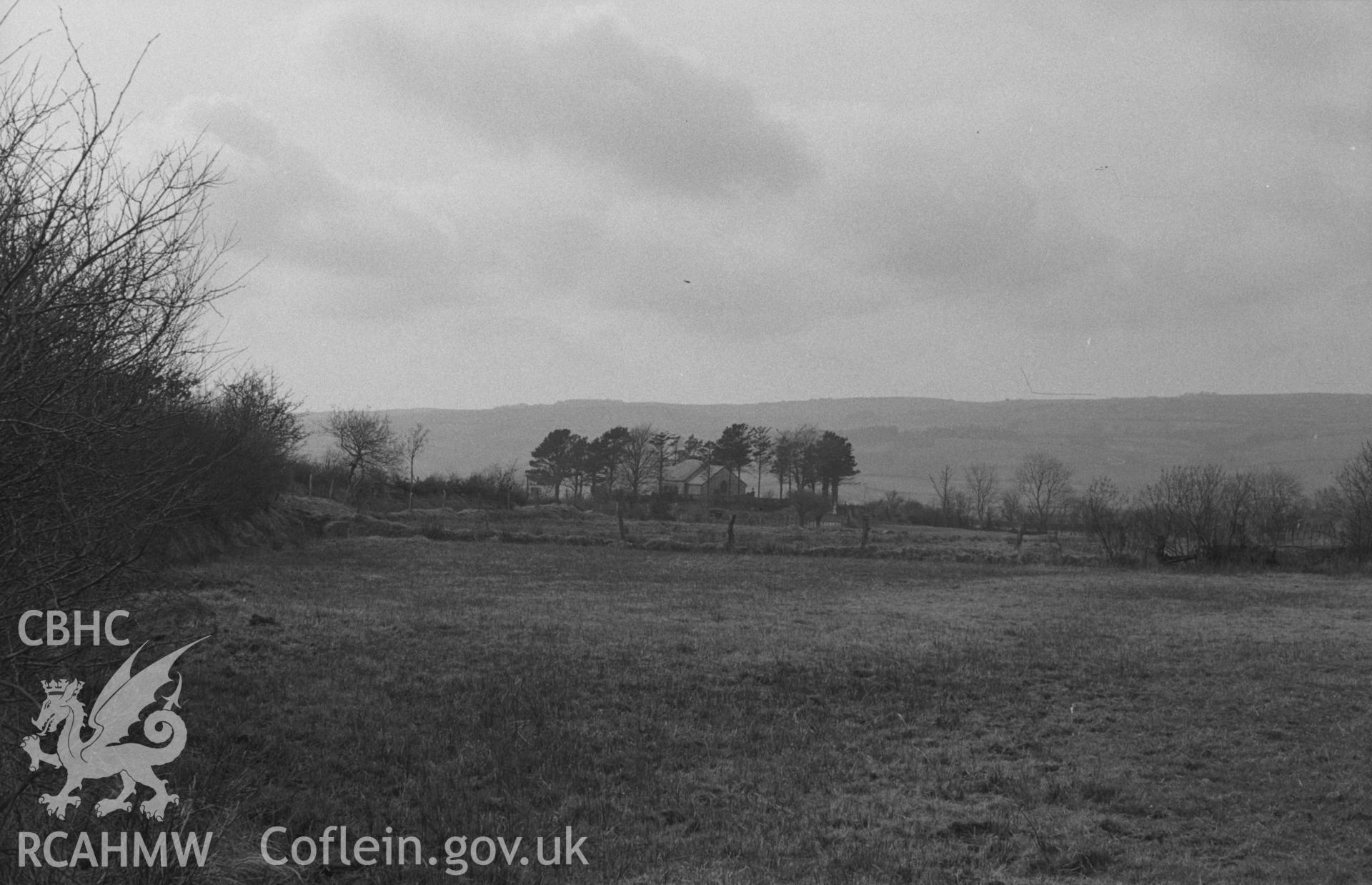 Digital copy of a black and white negative showing distant view of St. Padarns church, Llanbadarn Odyn. Photographed in April 1964 by Arthur O. Chater from by the road from Sarn Helen, Grid Reference SN 6369 6037, looking west north west.