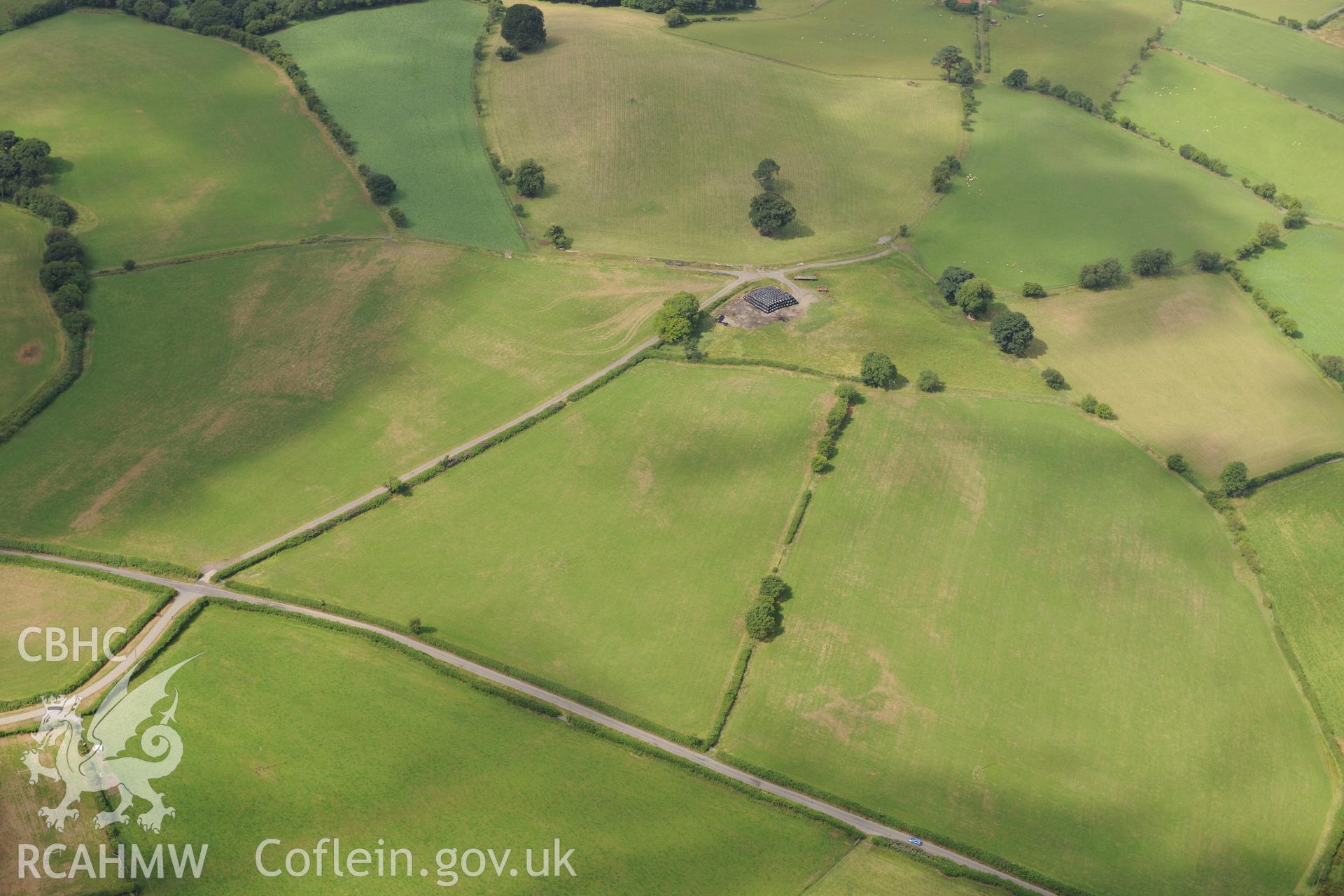 Cropmarks of Roman camp west of Caerau Roman fort and possible square ditched barrow, Beulah, west of Builth Wells. Oblique aerial photograph taken during the Royal Commission?s programme of archaeological aerial reconnaissance by Toby Driver on 1st August 2013.