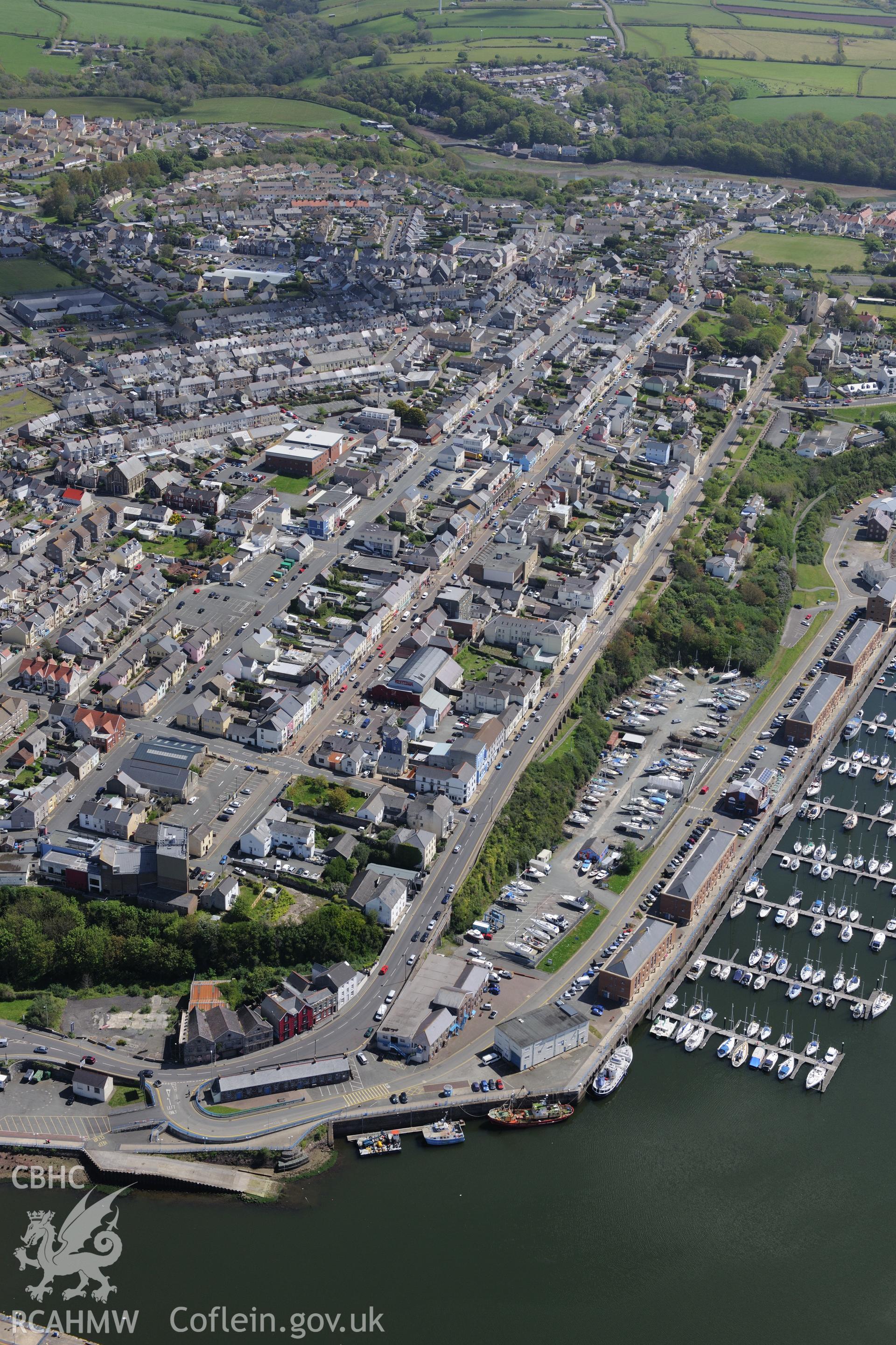 Milford Haven docks and the town of Milford Haven, Pembrokeshire. Oblique aerial photograph taken during the Royal Commission's programme of archaeological aerial reconnaissance by Toby Driver on 13th May 2015.