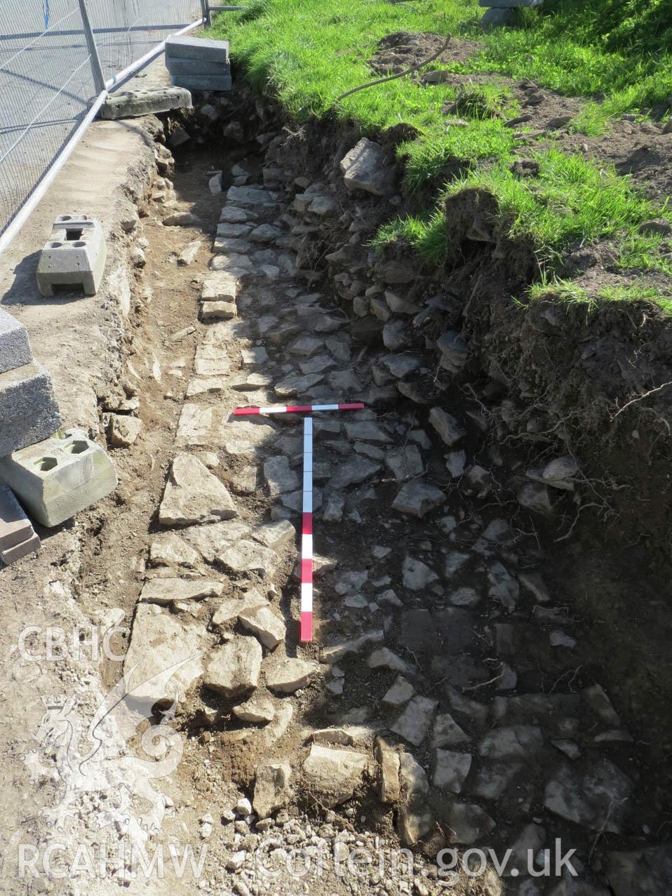 'Post-excavation shot of stone foundations at the north-east corner of the site. Scales: 1x0.5m & 1x1m. Looking south.' Photographed as part of Archaeological Watching Brief of Upper House Farm, Painscastle, by Archaeology Wales.