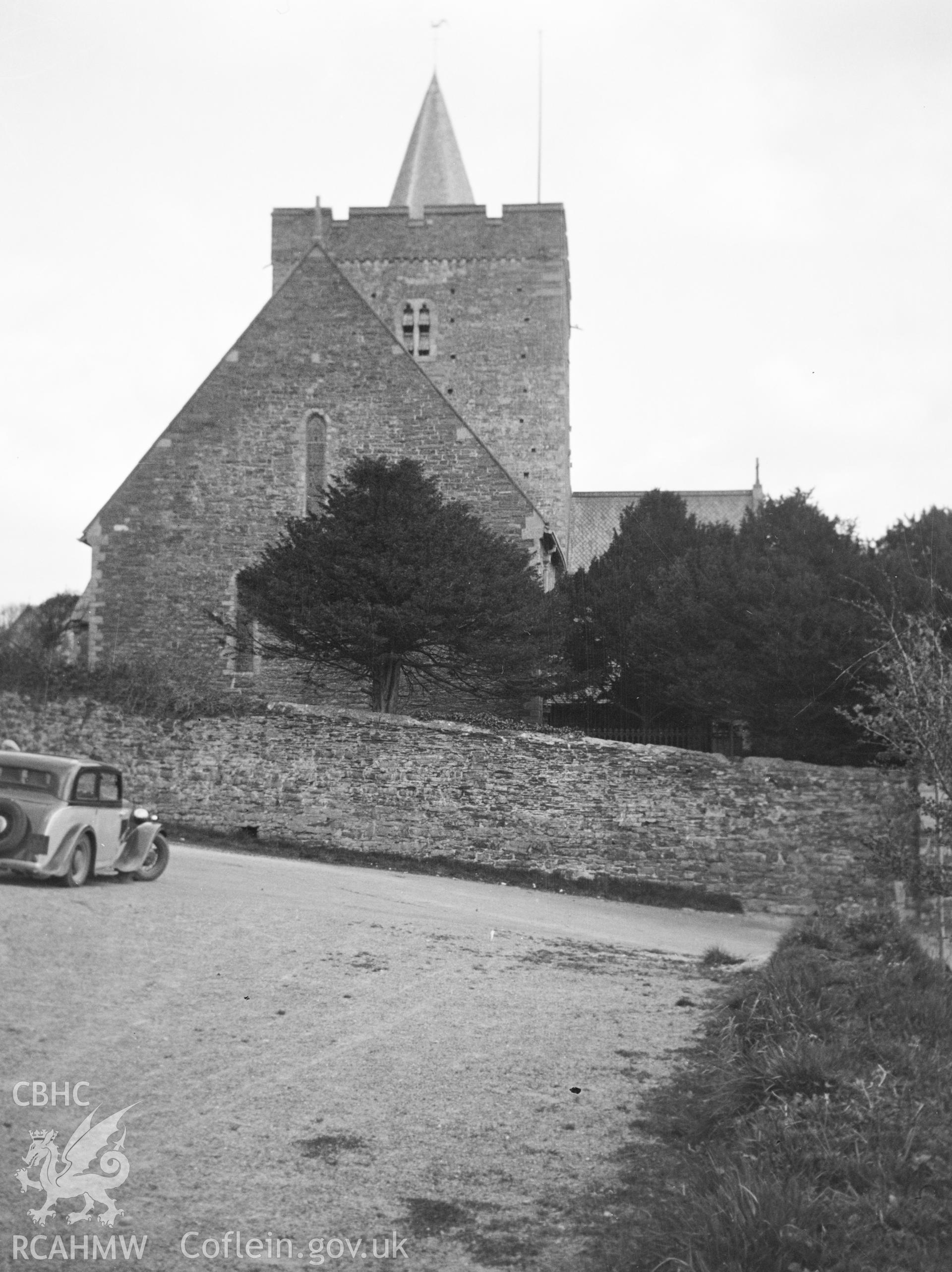 Digital copy of a nitrate negative showing early exterior view of St Padarn's Church, Llanbadarn Fawr, Ceredigion, with car in foreground. From the National Building Record Postcard Collection.