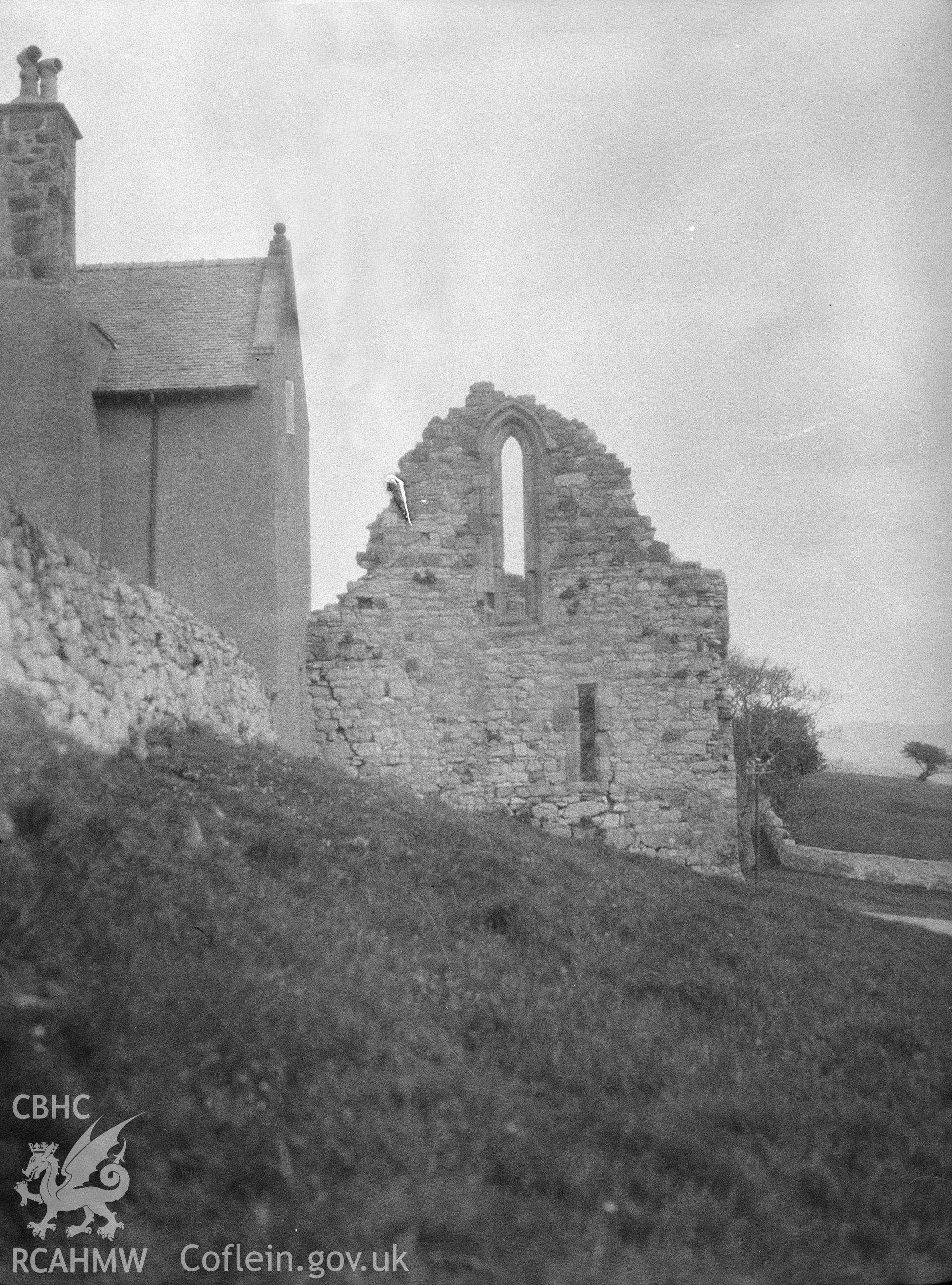 Digital copy of a nitrate negative showing exterior view of Penmon Priory Refectory ruins, from the west. From the National Building Record Postcard Collection.