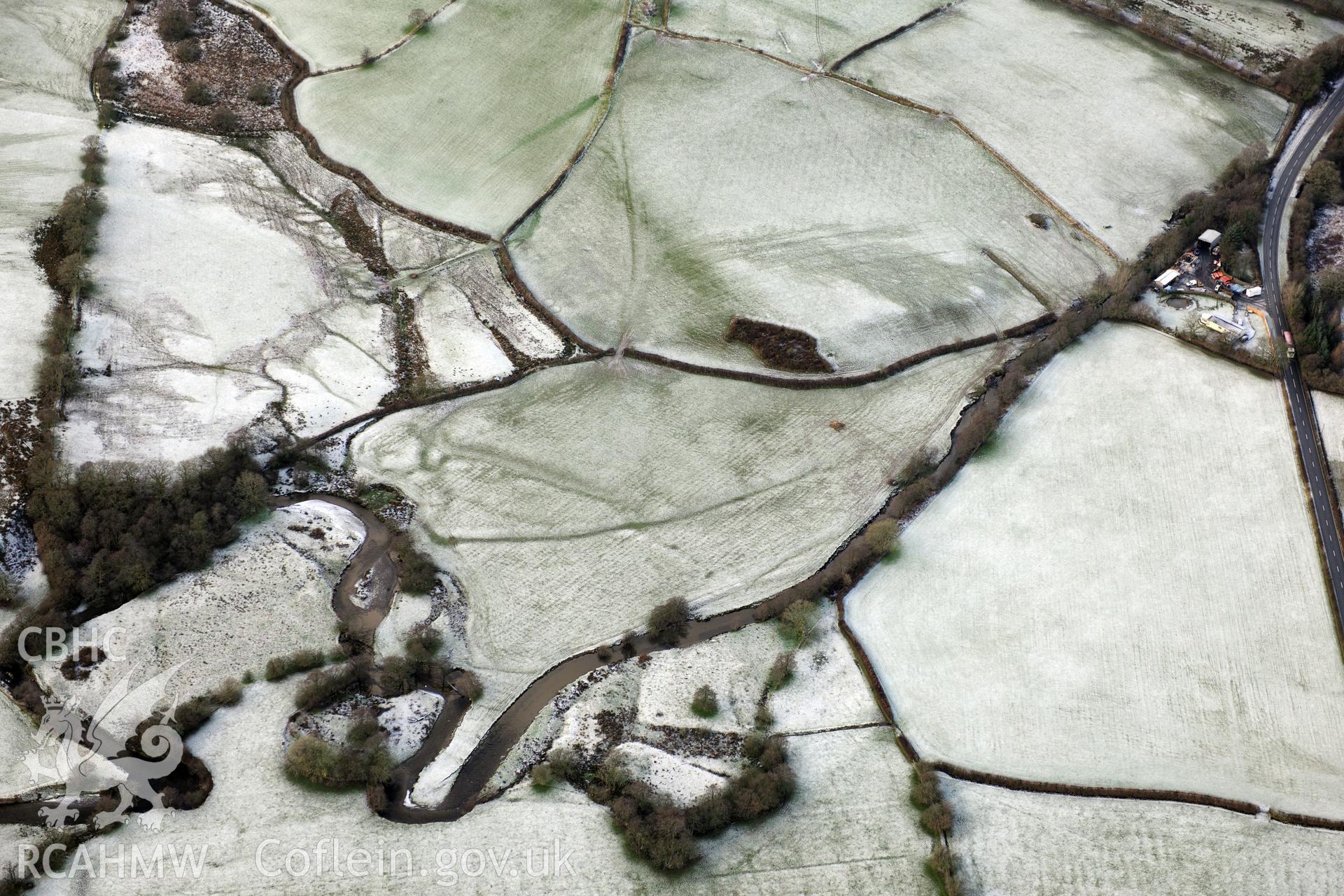 Riverside earthworks to the south-east of Caerau Roman Fort, Beulah, west of Builth Wells. Oblique aerial photograph taken during the Royal Commission?s programme of archaeological aerial reconnaissance by Toby Driver on 15th January 2013.