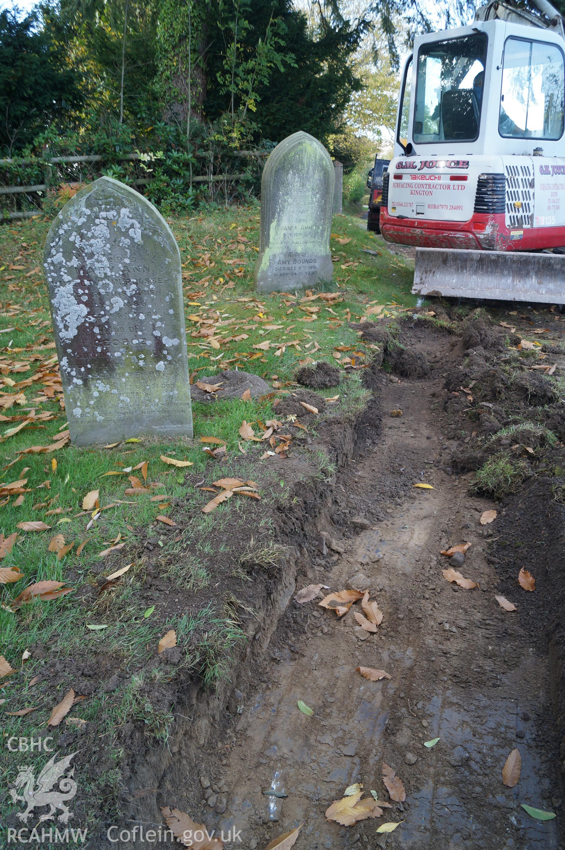'Looking west northwest at excavated Trench B, on southwestern side of path, showing apparent upper fill of grave, possibly part of family associated with adjacent gravestone.' Photograph & description by Jenny Hall & Paul Sambrook of Trysor, 16/10/2017.