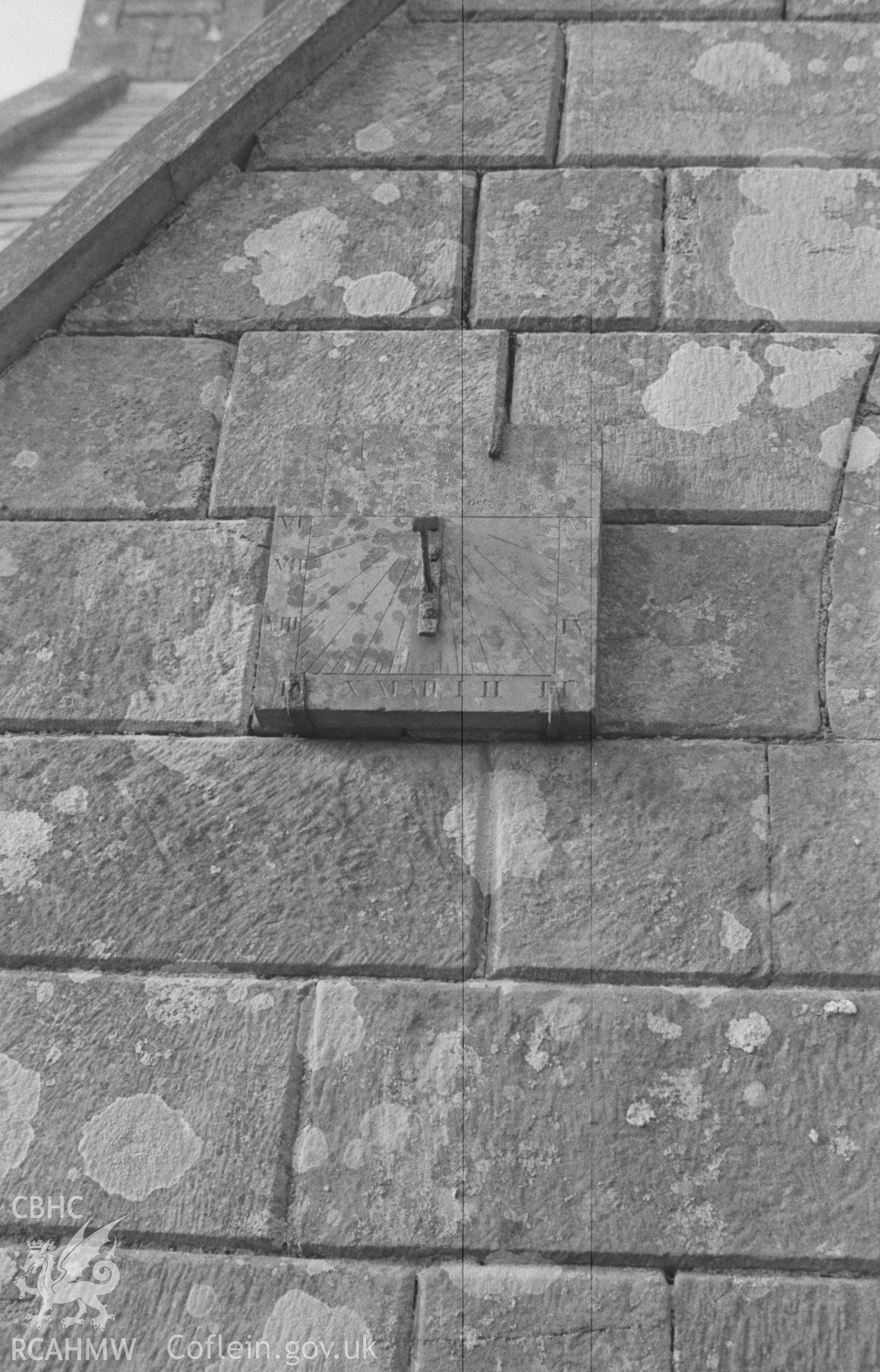 Digital copy of a black and white negative showing sundial on the wall of the porch at St Michael's Church, Troedyraur, east of Cardigan. Photographed in April 1963 by Arthur O. Chater from Grid Reference SN 3271 4536, looking north.