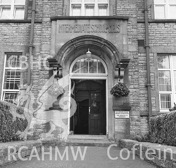 Digitised black and white photograph showing detailed view of entrance to the 'Girls' Intermediate School, Aberdare,' dated 2014. Included in material associated with building recording conducted by Archaeology Wales, February 2018.