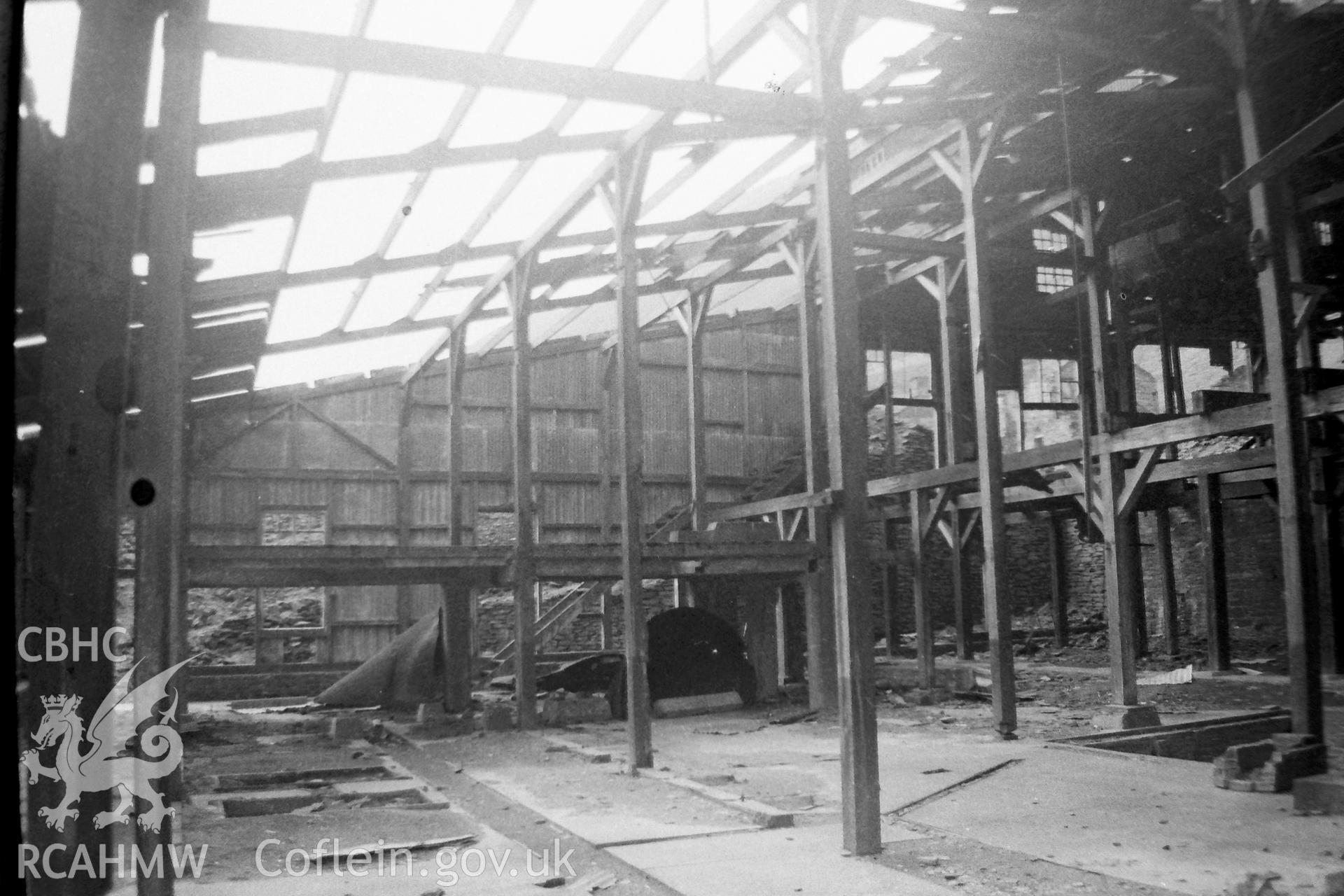 Digitised black and white photograph showing interior of large, roofless works shed at Cwmystwyth. Photographed by Martin Davies as part of his Bachelor of Architecture dissertation from the University of Nottingham, 1979.
