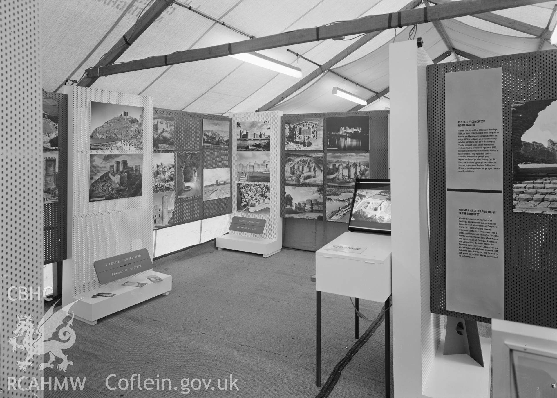 Digital copy of a nitrate negative showing Ministry of Public Building and Works. Exhibition of Ancient Monuments in Wales at The National Eisteddfod, Bala, 1967. "Edwardian Castles (2) and coloured slides projector".