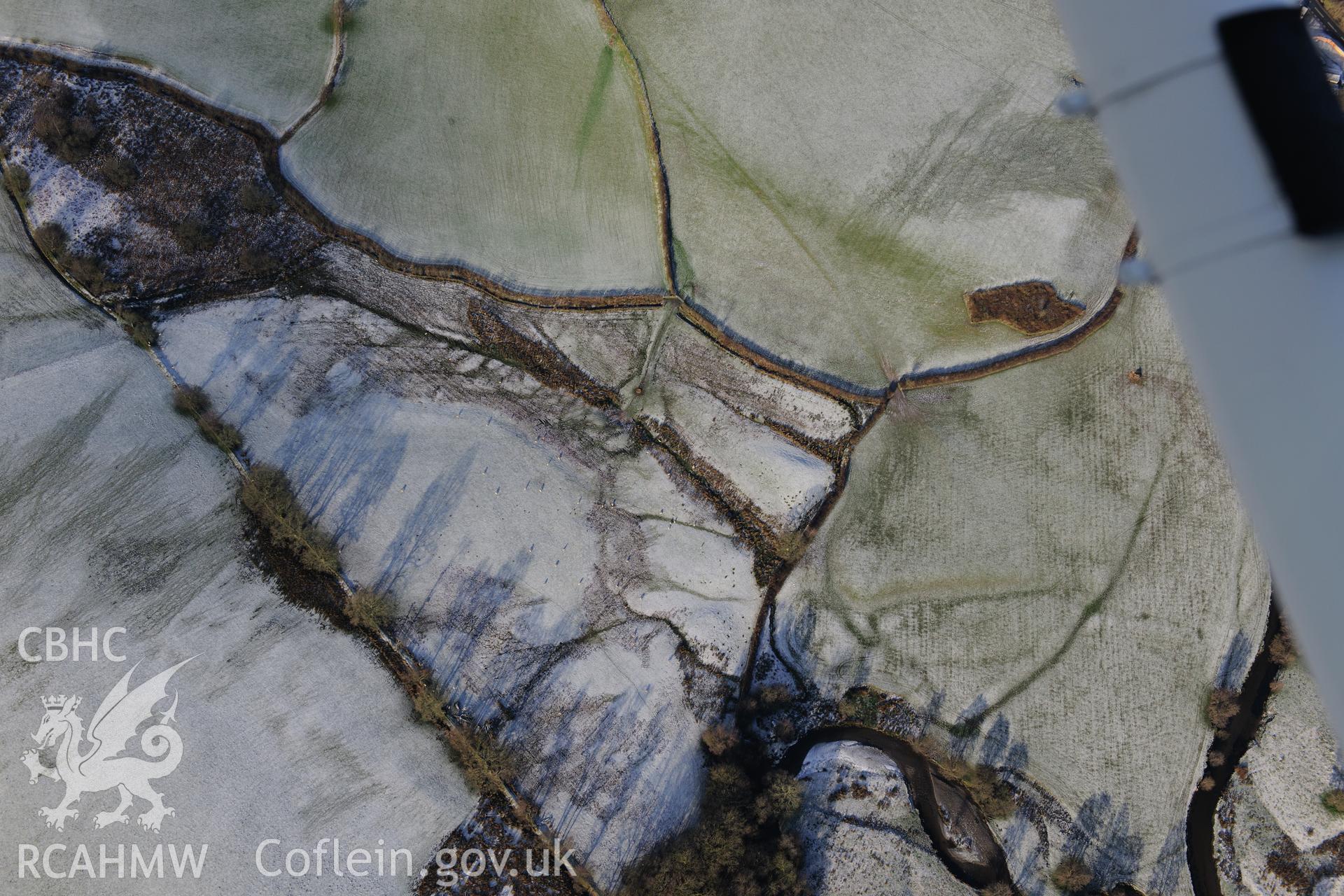 Riverside earthworks to the south-east of Caerau Roman Fort, Beulah, west of Builth Wells. Oblique aerial photograph taken during the Royal Commission?s programme of archaeological aerial reconnaissance by Toby Driver on 15th January 2013.