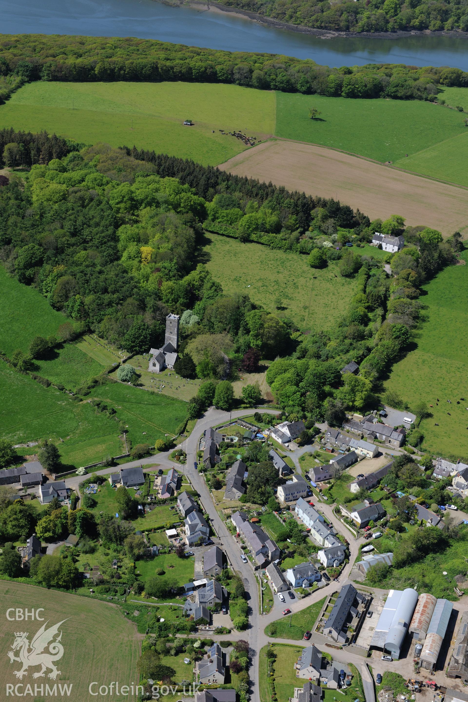 St. Cadog's Church and the village of Lawrenny. Oblique aerial photograph taken during the Royal Commission's programme of archaeological aerial reconnaissance by Toby Driver on 13th May 2015.