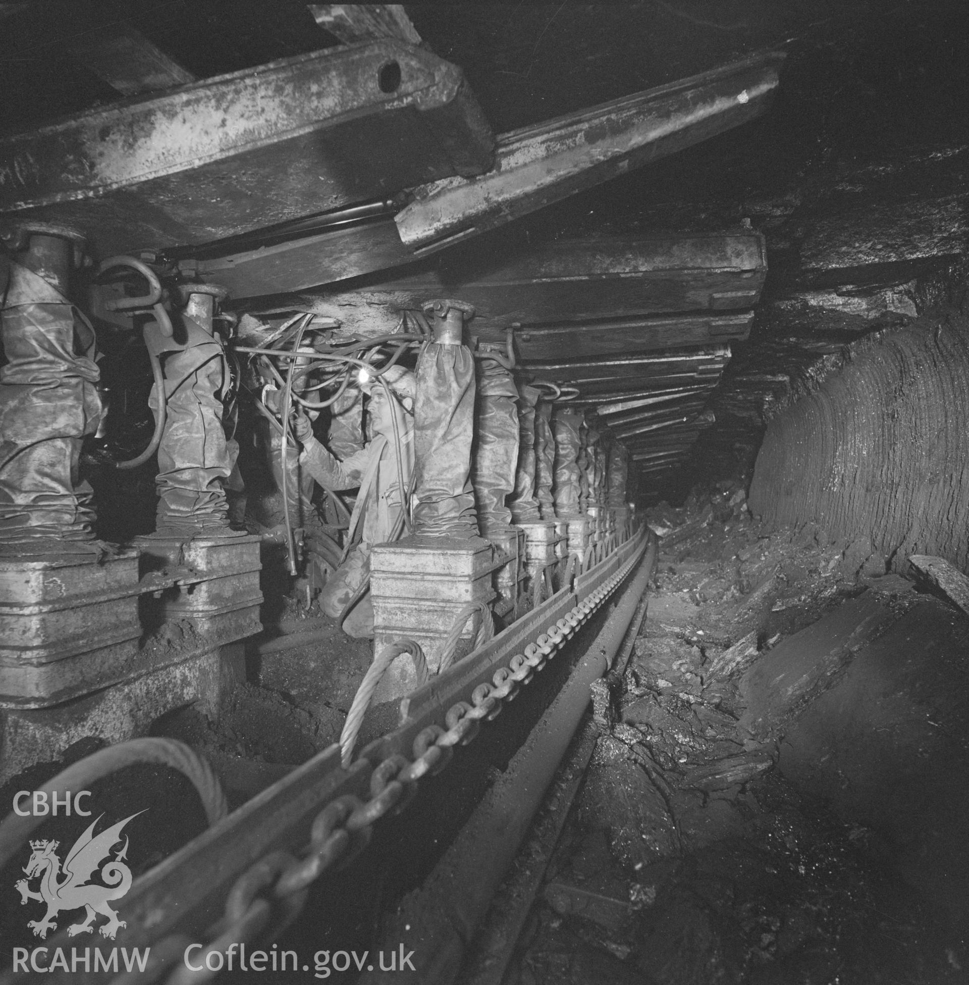 Digital copy of an acetate negative showing collier working on hydraulic roof supports at Oakdale Colliery, from the John Cornwell Collection.
