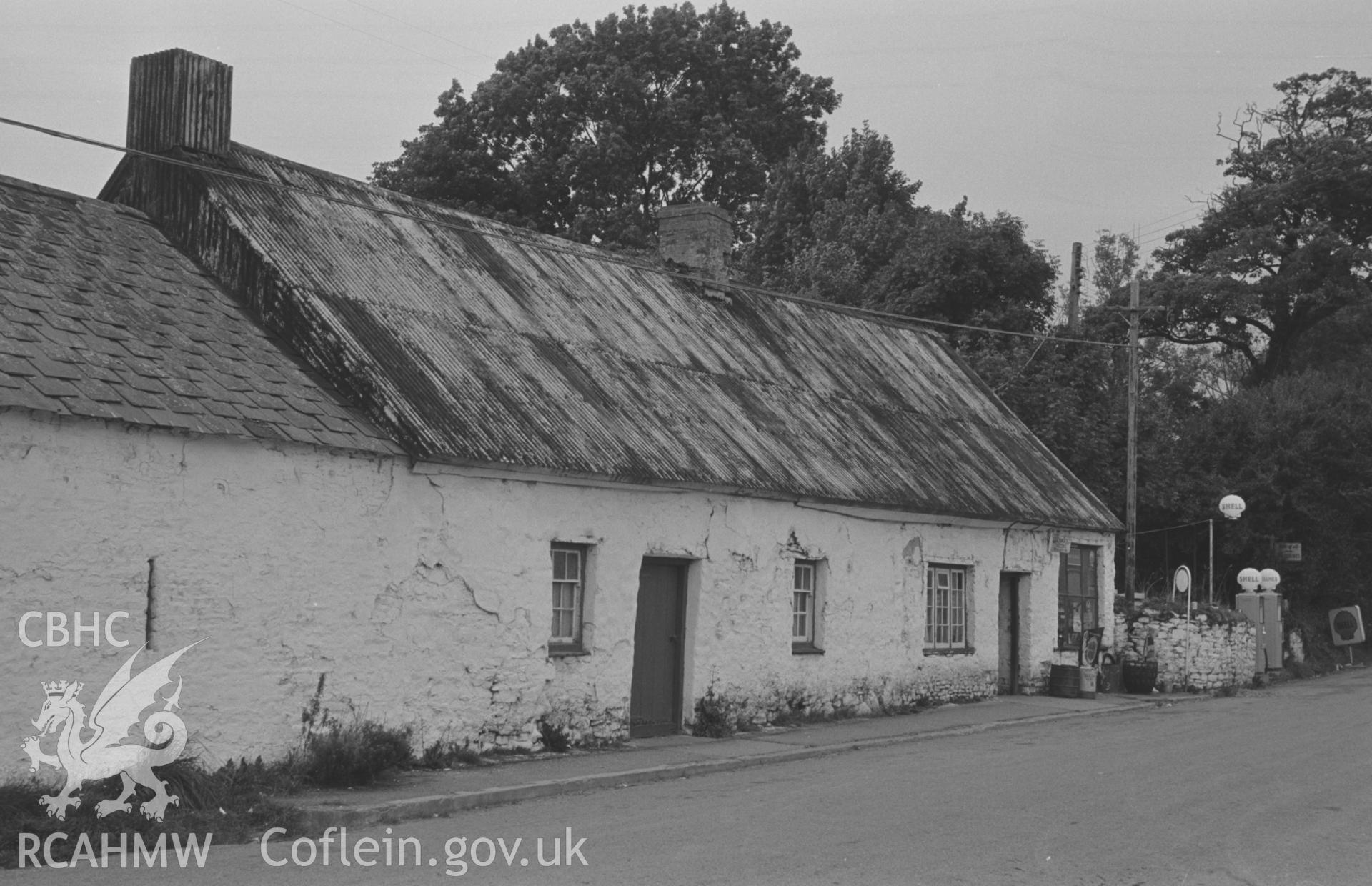 Digital copy of a black and white negative showing cottages and Shell petrol pumps on west side of the road at the north end of Talsarn. Photographed by Arthur O. Chater on 5th September 1966 looking north north west from Grid Ref SN 545 563.