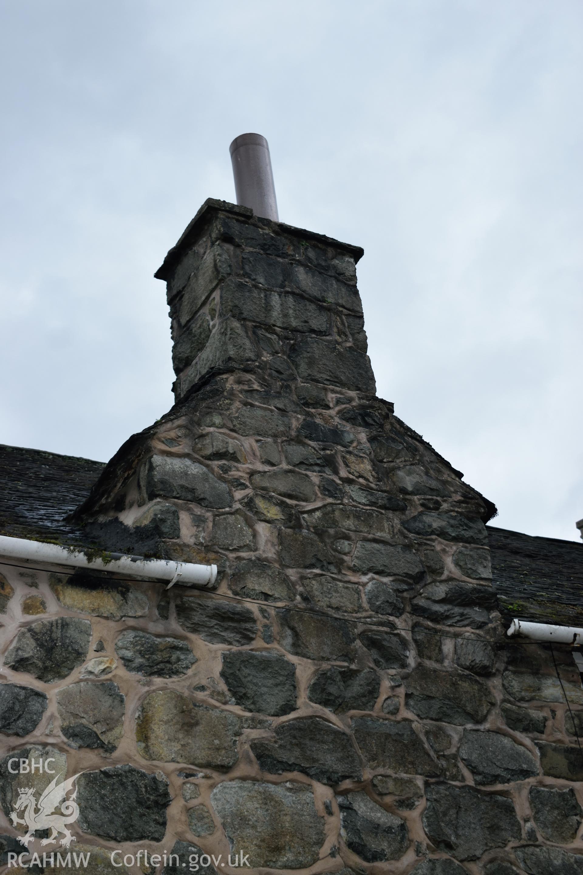 Colour photograph showing view looking south west at the lateral chimney of Y Sospan, Llys Owain, Dolgellau. Photographed by I. P. Brookes of Engineering Archaeological Services, June 2019.