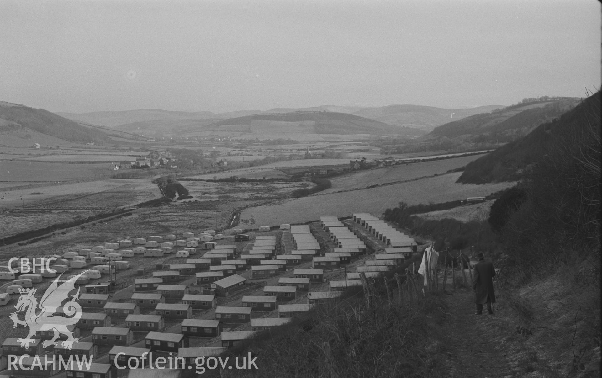 Black and White photograph showing view of caravans and chalets at Glan-y-Mor-Fach, with Llangorwen beyond. Photographed by Arthur Chater in December 1962 from Grid Reference SN 584 829, looking east north east.
