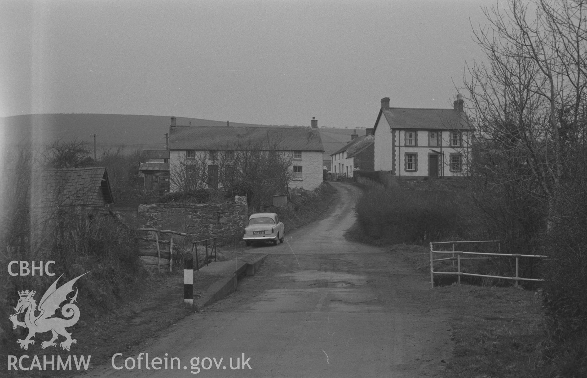 Black and White photograph showing view of Penrhyncoch village from the ford across Nant Silo on the lane to Llwyn-Gronw. Photographed by Arthur Chater in April 1962 at Grid Reference SN 642 839, looking north.