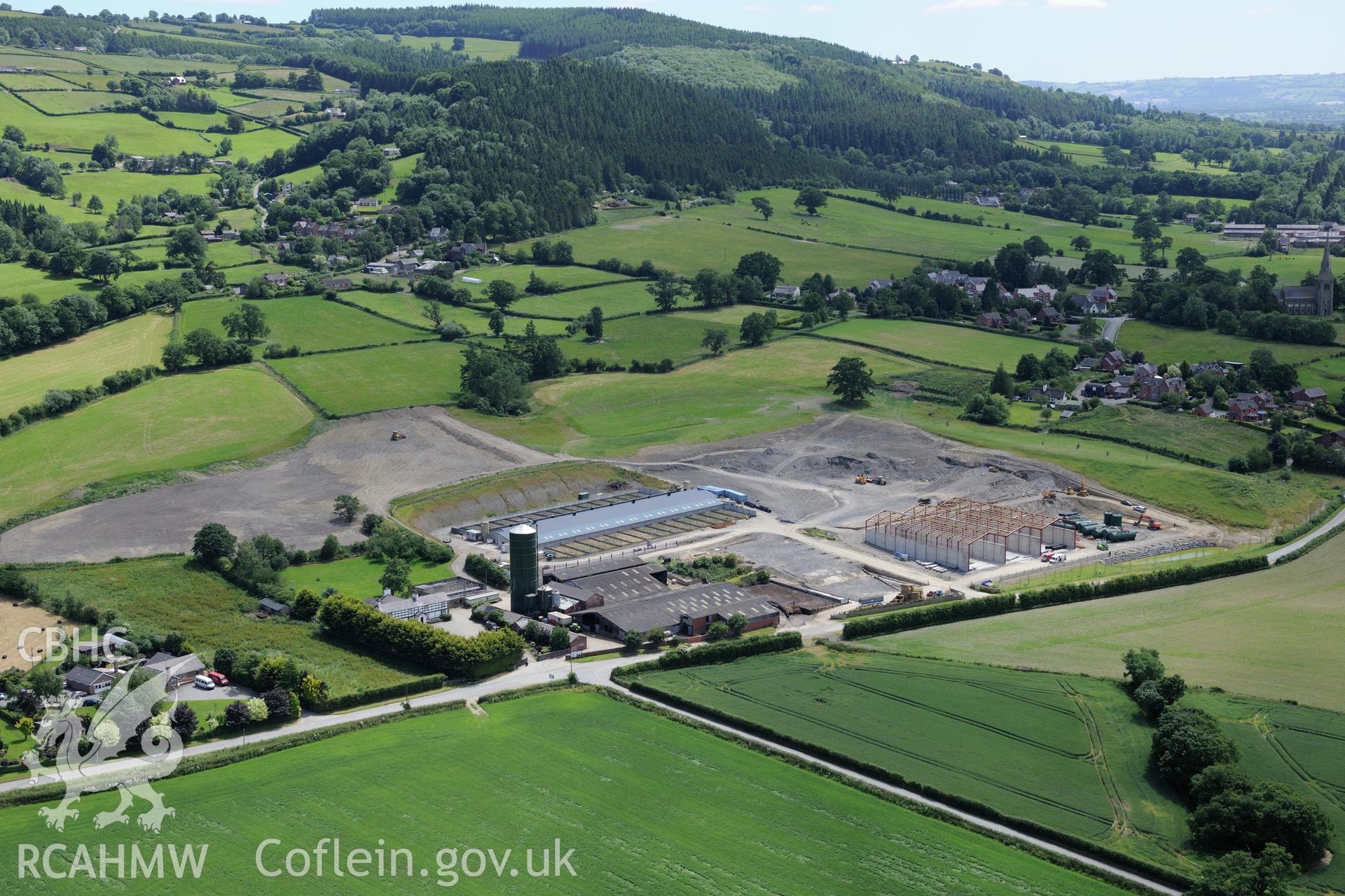 Lower Leighton farmhouse and the new 'super dairy' under construction at Lower Leighton Farm, Leighton, Welshpool. Oblique aerial photograph taken during the Royal Commission's programme of archaeological aerial reconnaissance by Toby Driver on 30th June 2015.