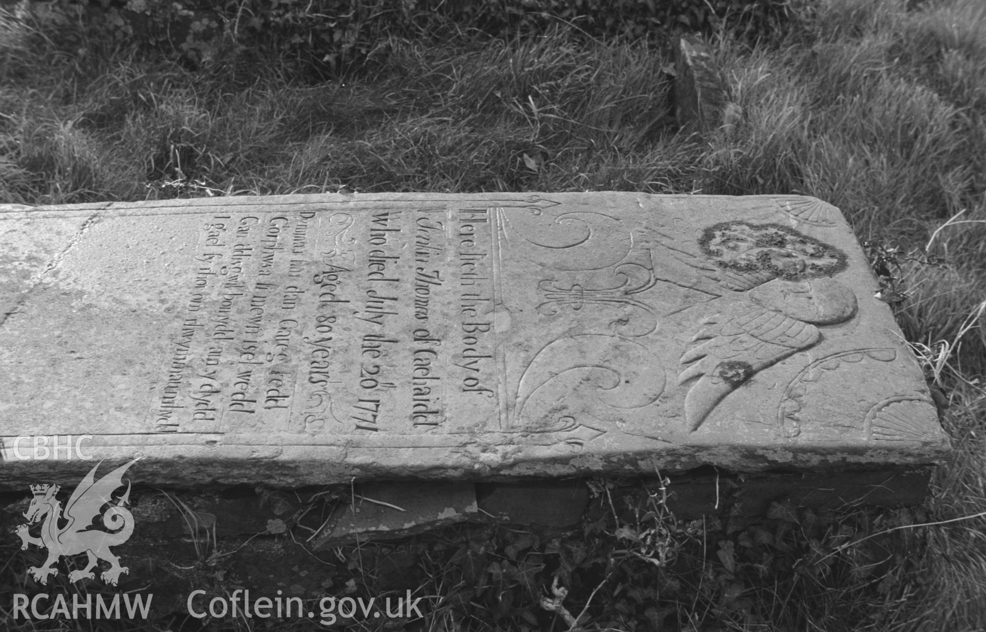 Digital copy of a black and white negative showing gravestone to Jenkin Thomas of Caehaidd, dated 1771, on south side of St. David's church, Henfynyw. Photographed in December 1963 by Arthur O. Chater from Grid Reference c. SN 4474 6118.