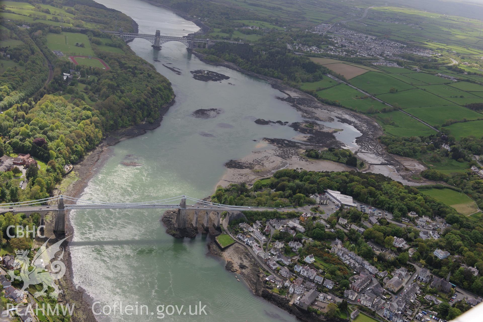 The town of Menai Bridge, with Menai Suspension Bridge and the Britannia Bridge. Oblique aerial photograph taken during the Royal Commission?s programme of archaeological aerial reconnaissance by Toby Driver on 22nd May 2013.