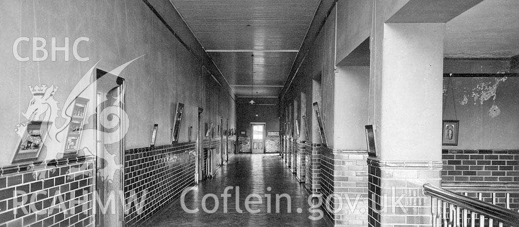 Digitised black and white photograph of the upper corridor at Aberdare Girls Upper Comprehensive School, dated 1935. Included in material associated with a building recording conducted by Archaeology Wales, February 2018.