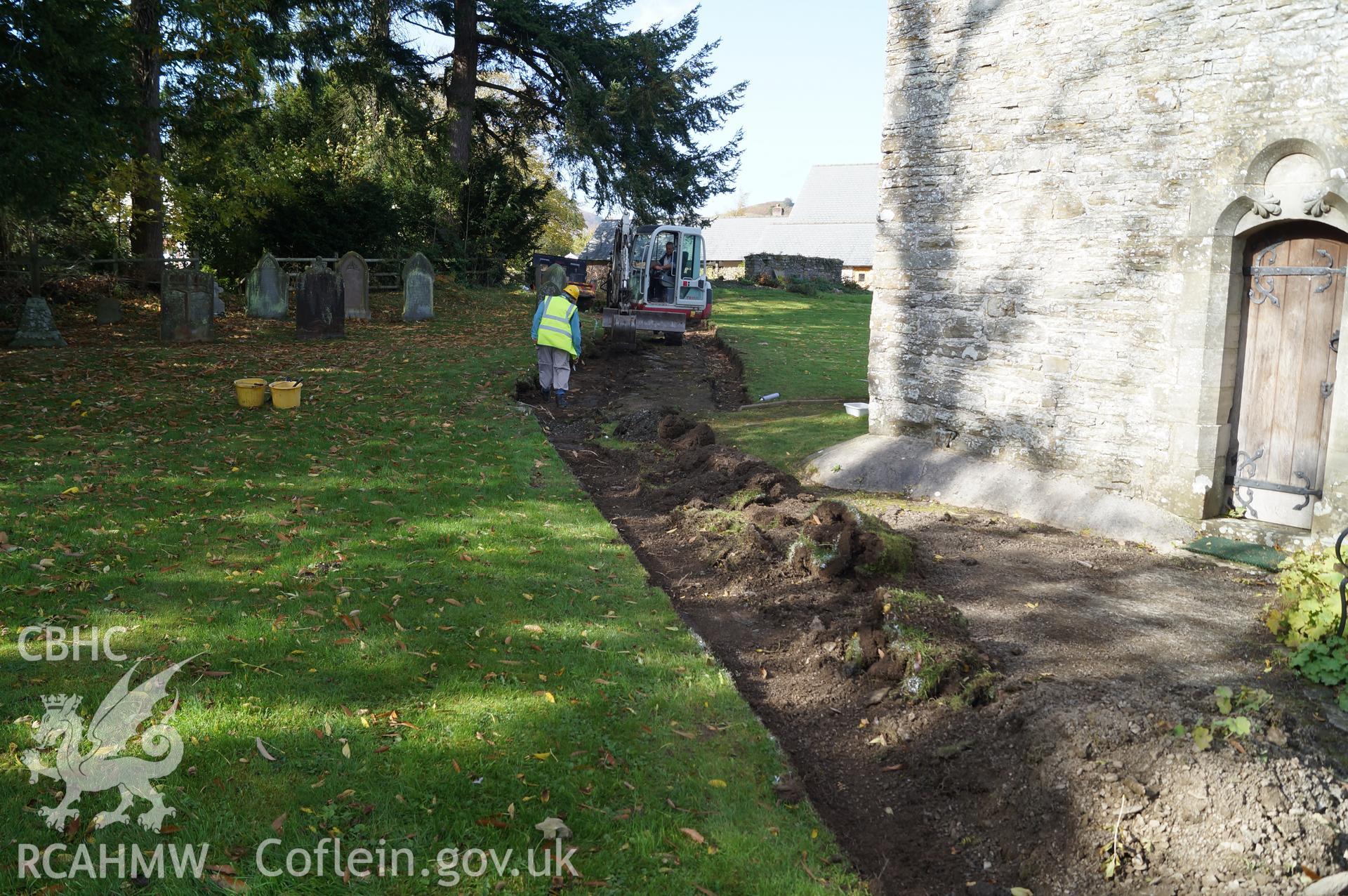 View 'looking west northwest towards where only the turf was removed from the area of path in front of the church, no archaeologically significant contexts observed.' Photograph and description by Jenny Hall and Paul Sambrook of Trysor, 16th October 2017.