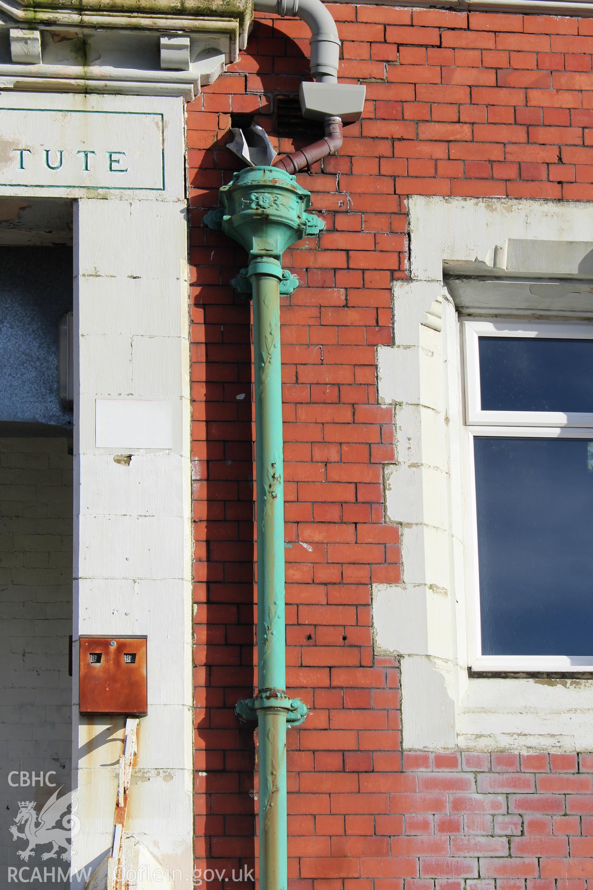 Detailed view of drainpipe next to entrance at front elevation of the Railway Institute, Bangor. Photographed during survey conducted by Sue Fielding for the RCAHMW on 4th April 2016.