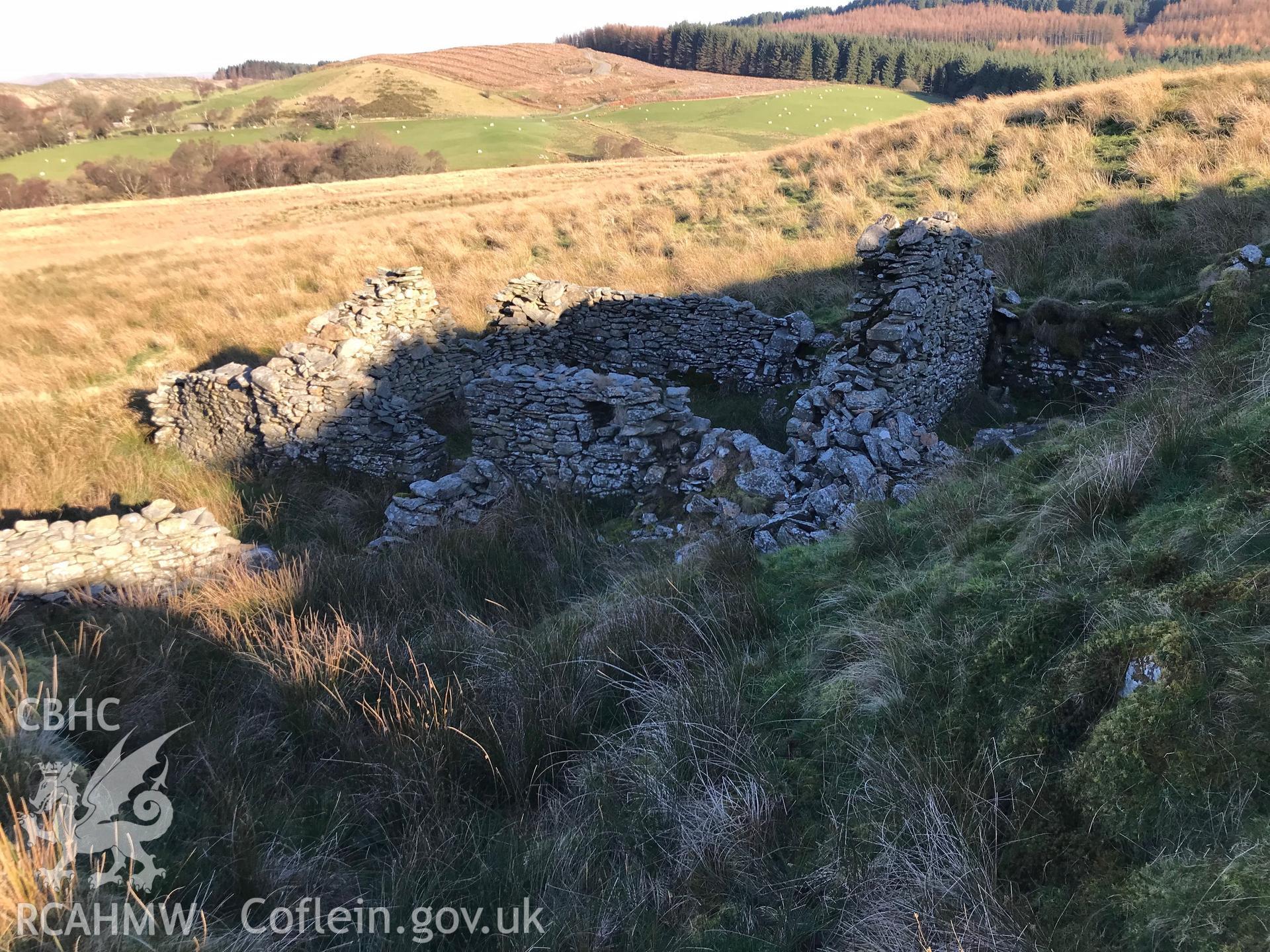 Exterior view of the remains of Gwndwn-Gwynau-Isa or Caron-Uwch-Clawdd house, which is south west of Bryneithinog farm, Ystrad Fflur. Colour photograph taken by Paul R. Davis on 18th November 2018.