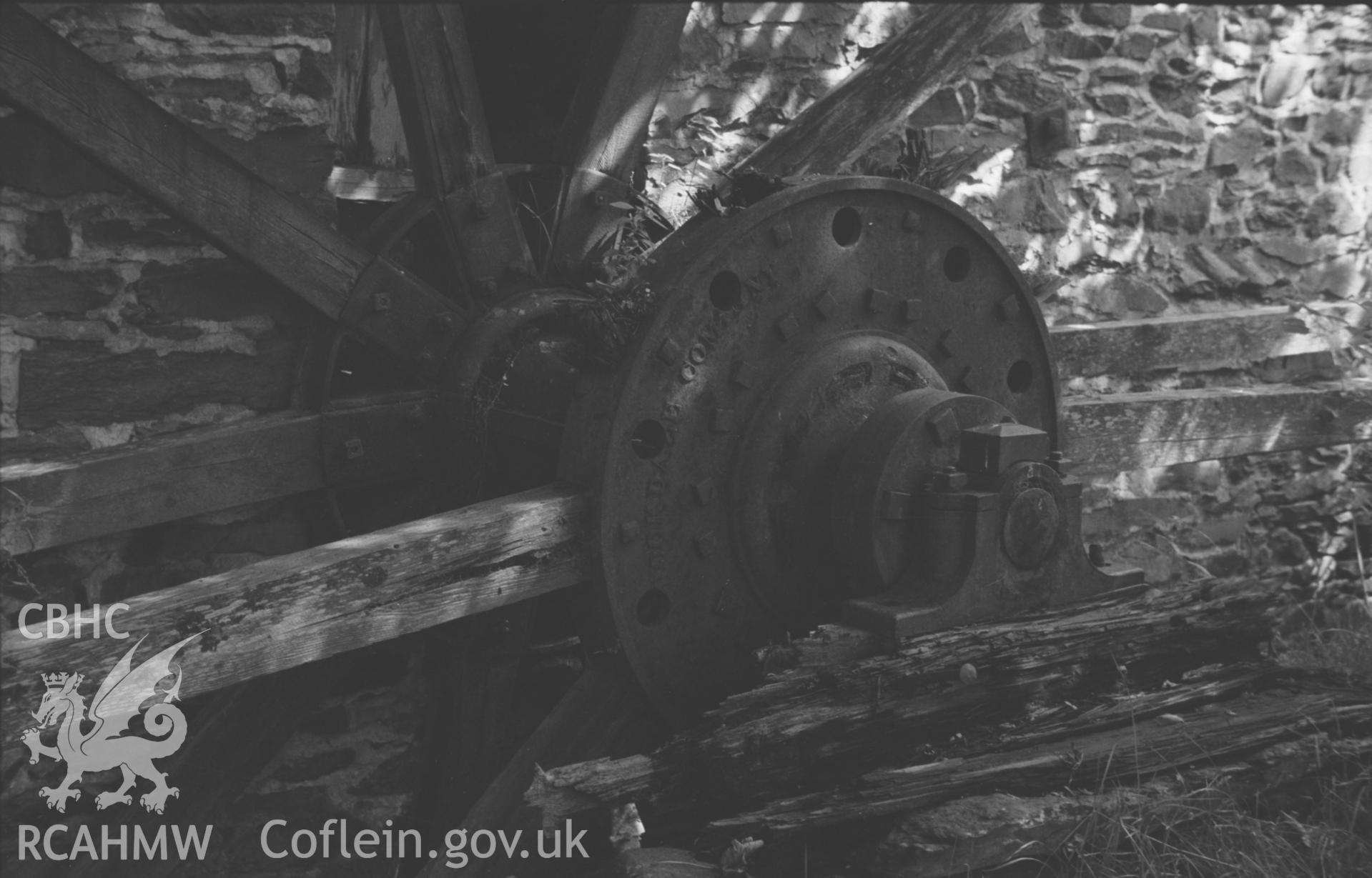 Digital copy of a black and white negative showing the hub, axle and supports of the overshot, iron waterwheel of Felin Fflur, Ystrad Fflur. Photographed by Arthur O. Chater in August 1967. (Looking east from Grid Reference SN 7204 6429).