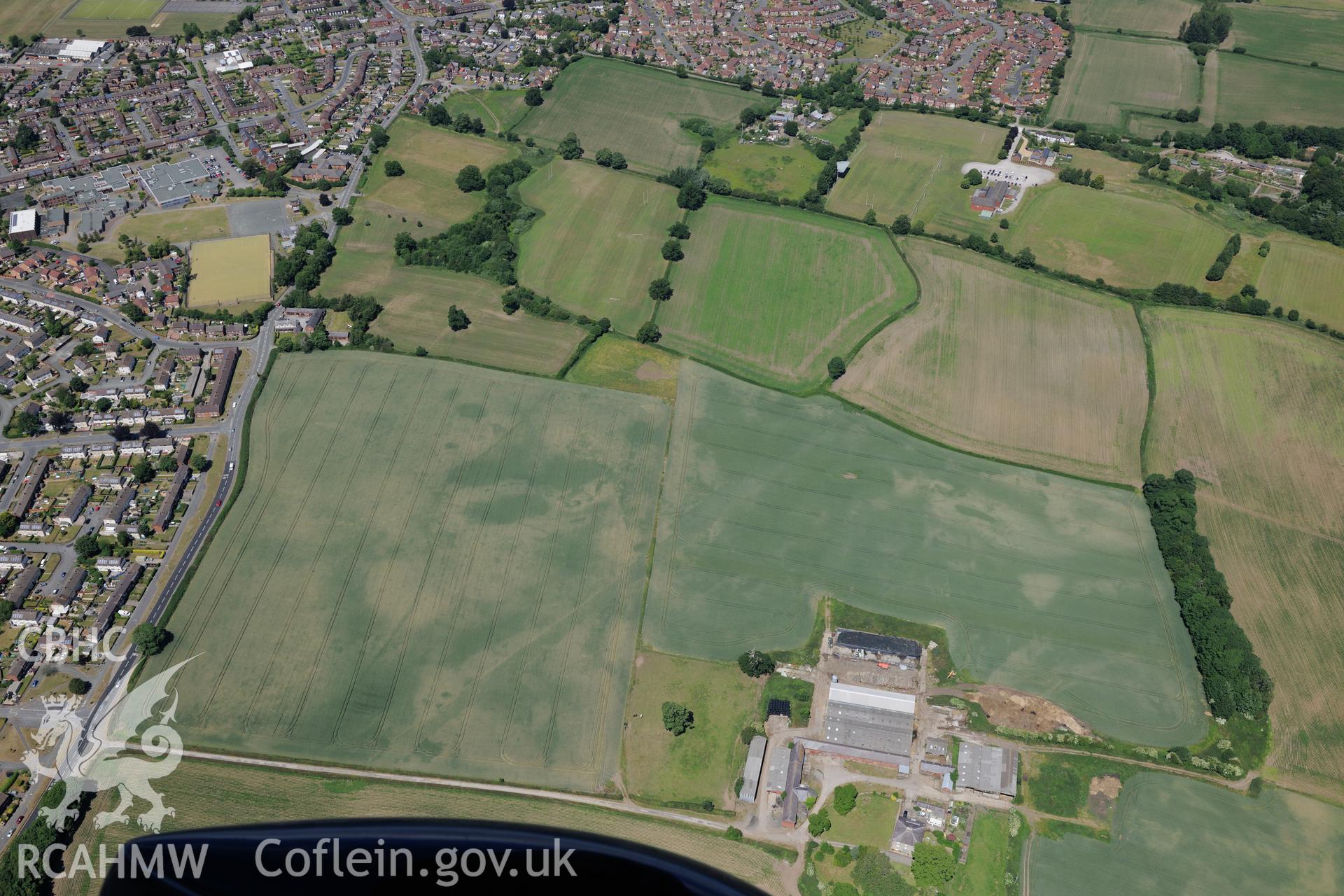 Cropmarks north west of Llwyn Knottia, with Wrexham on the right of the photograph. Oblique aerial photograph taken during the Royal Commission's programme of archaeological aerial reconnaissance by Toby Driver on 30th June 2015.