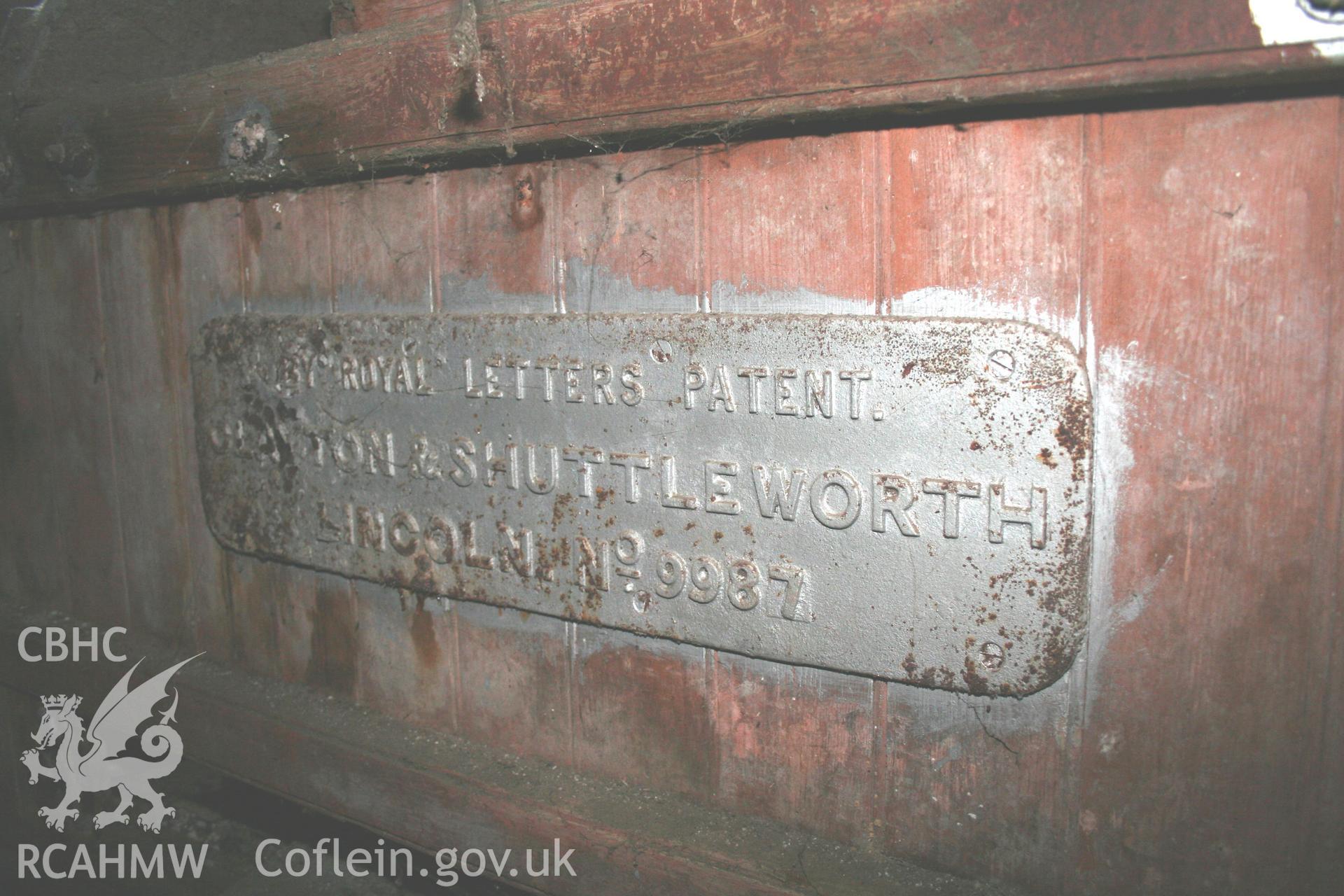 Detail of threshing machine: 'BY ROYAL LETTERS PATENT. CLAYTON & SHUTTLEWORTH. LINCOLN. No 9987' Photographic survey of the threshing machine in the threshing house at Tan-y-Graig Farm, Llanfarian. Conducted by Geoff Ward and John Wiles 11th December 2016.