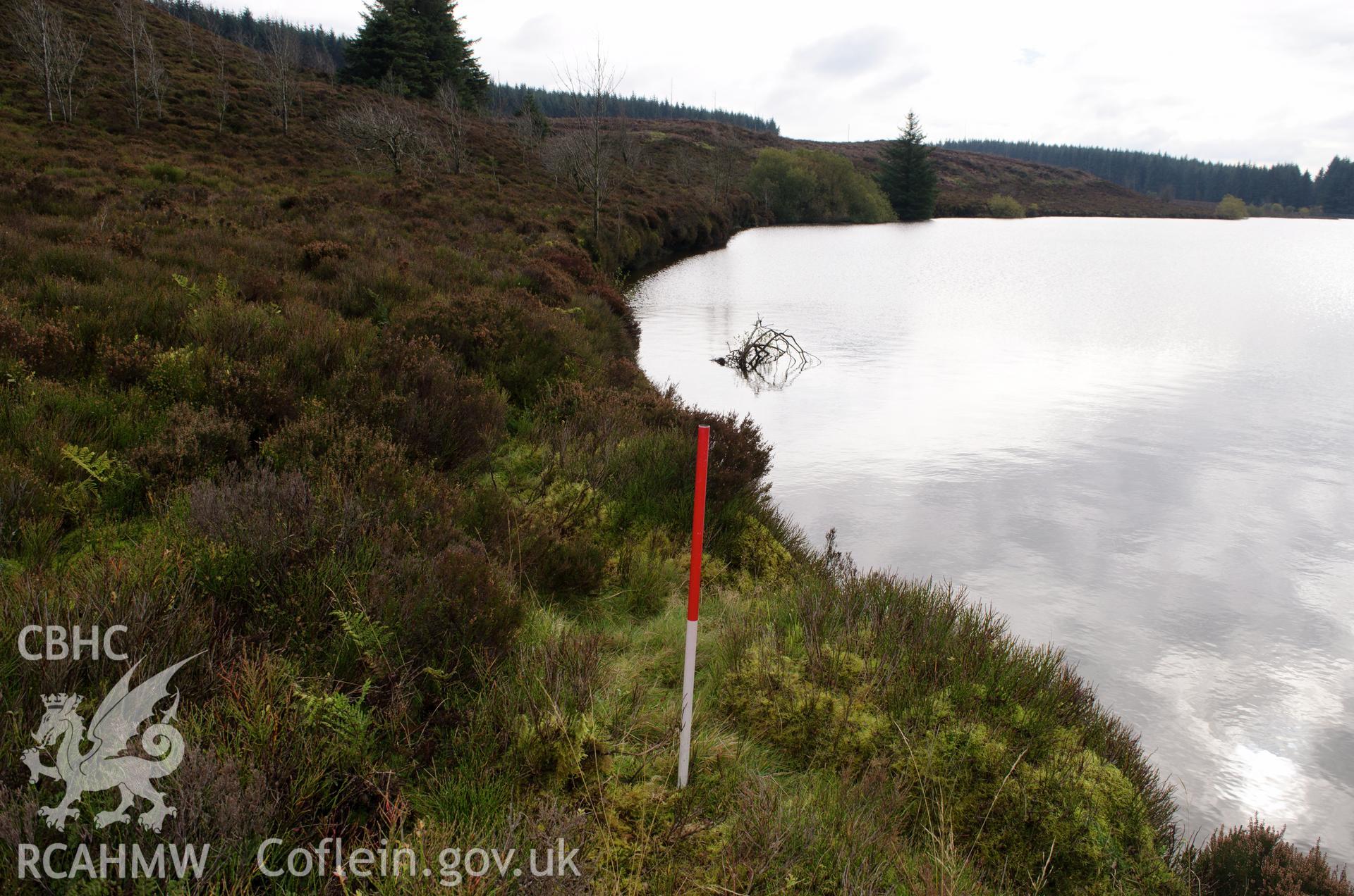 View from the north west of reservoir bank showing 1.5m drop to the water level at Llyn Bran, Mynydd Hiraethog. Photographed on 15th October 2018 by Gwynedd Archaeological Trust, as part of archaeological assessment of Llyn Bran. Project no. 2573.