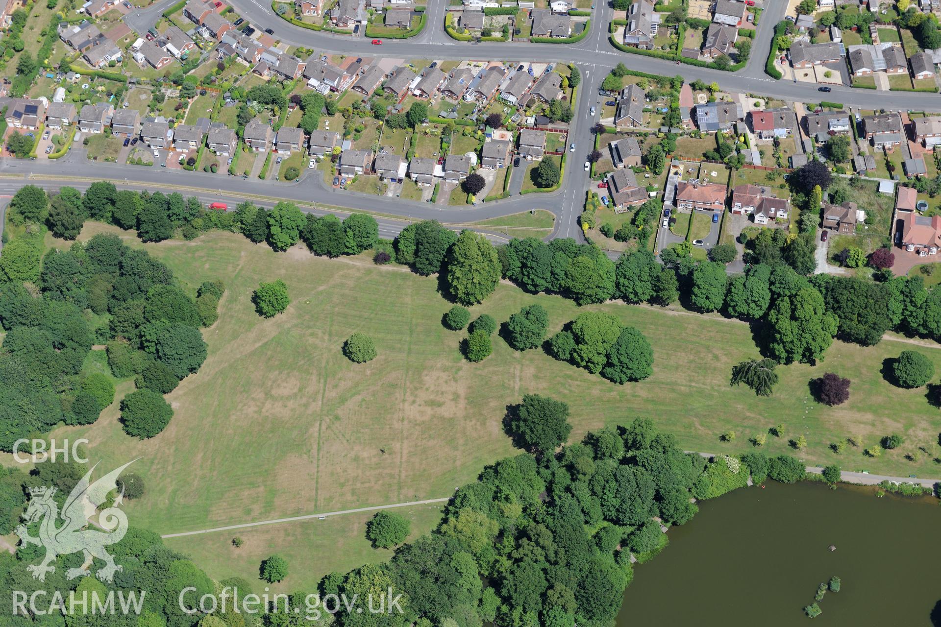 Acton Park and the barrow at Acton Park, with Wrexham beyond. Oblique aerial photograph taken during the Royal Commission's programme of archaeological aerial reconnaissance by Toby Driver on 30th June 2015.