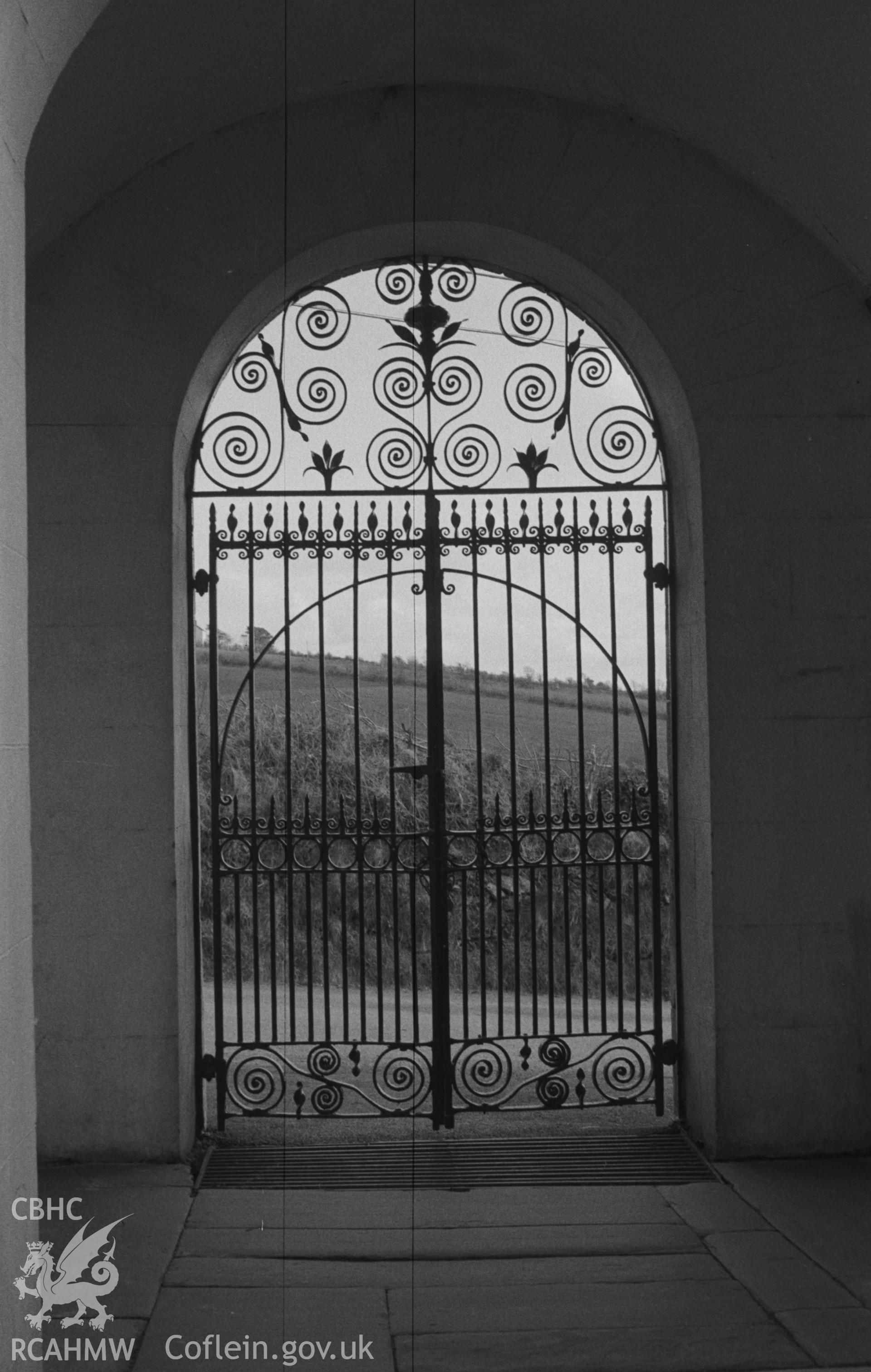 Digital copy of a black and white negative showing wrought iron gates at entrance to St Michael's Churchyard, Troedyraur, east of Cardigan. Photographed in April 1963 by Arthur O. Chater from Grid Reference SN 3271 4535, looking south south west.