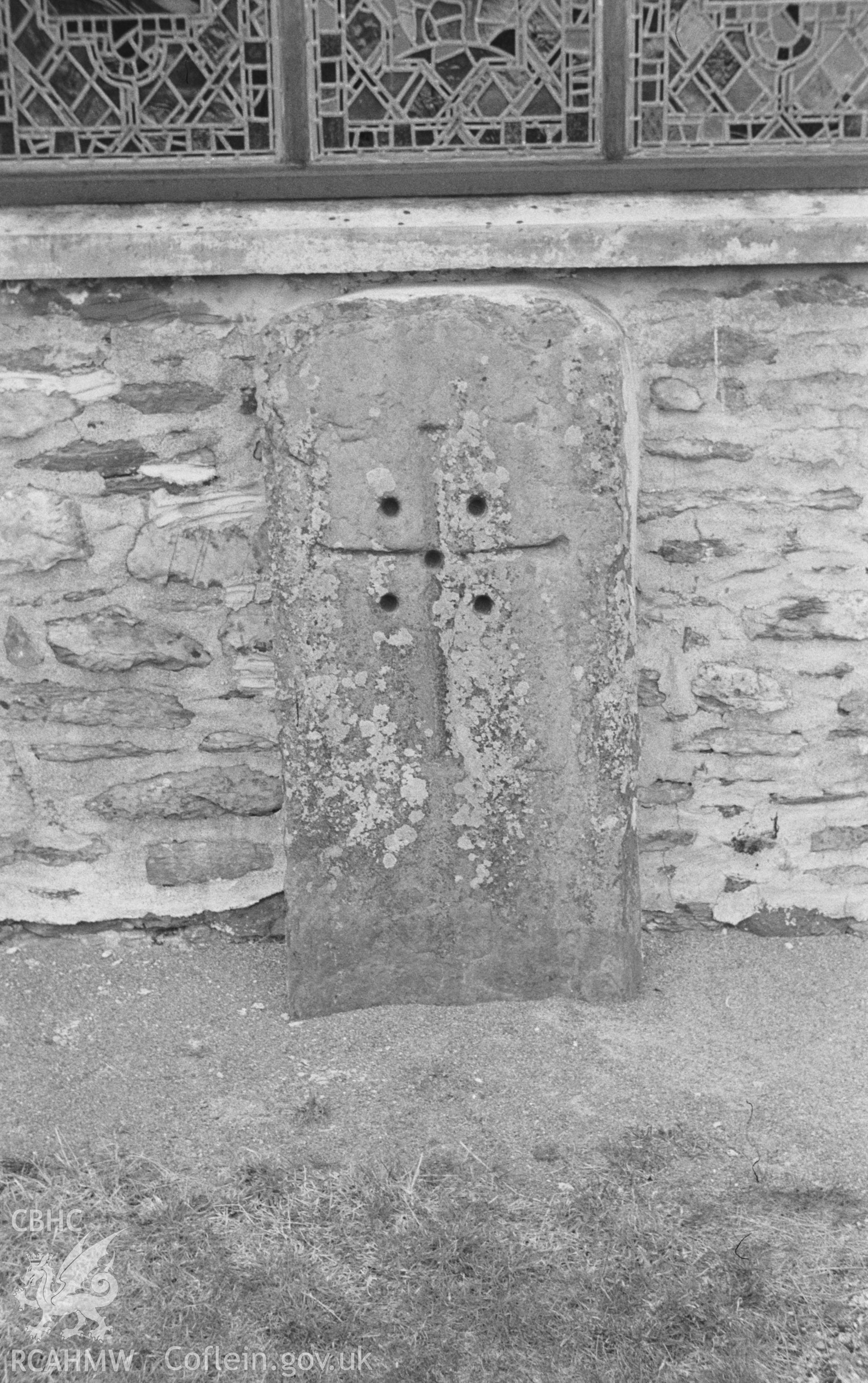 Digital copy of black & white negative showing 7th-9th century cross (from the Abbey cemetery) standing against east wall of St. Mary's Church, Strata Florida Abbey. Photographed in April 1964 by Arthur O. Chater from Grid Ref SN 7467 6576, looking west.