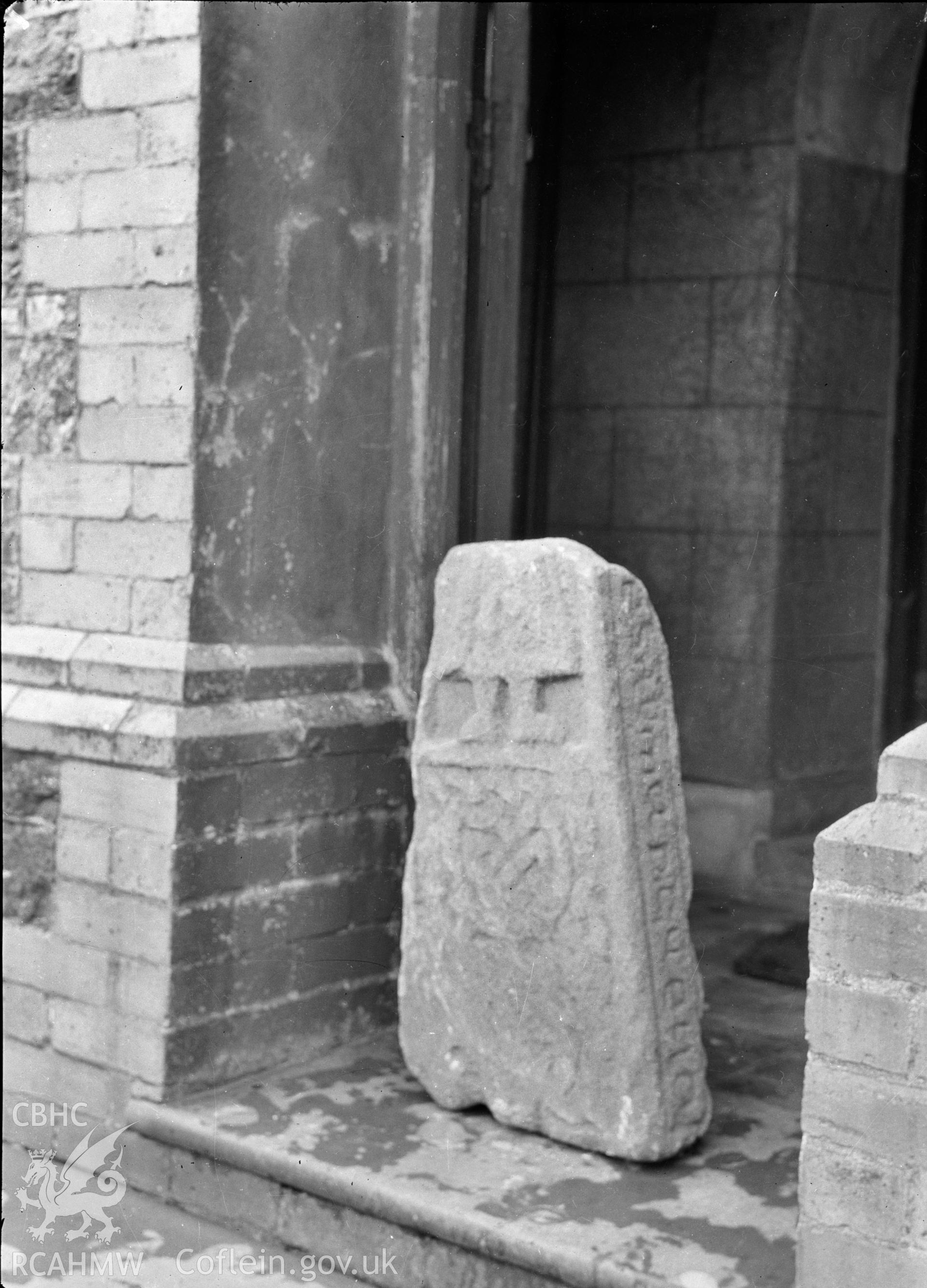 Digital copy of a nitrate negative showing an inscribed stone in the chapel on Bardsey Island. Transcript of reverse of black and white photograph: '57 x 6 / Caernarvon.' From the Cadw Monuments in Care Collection.