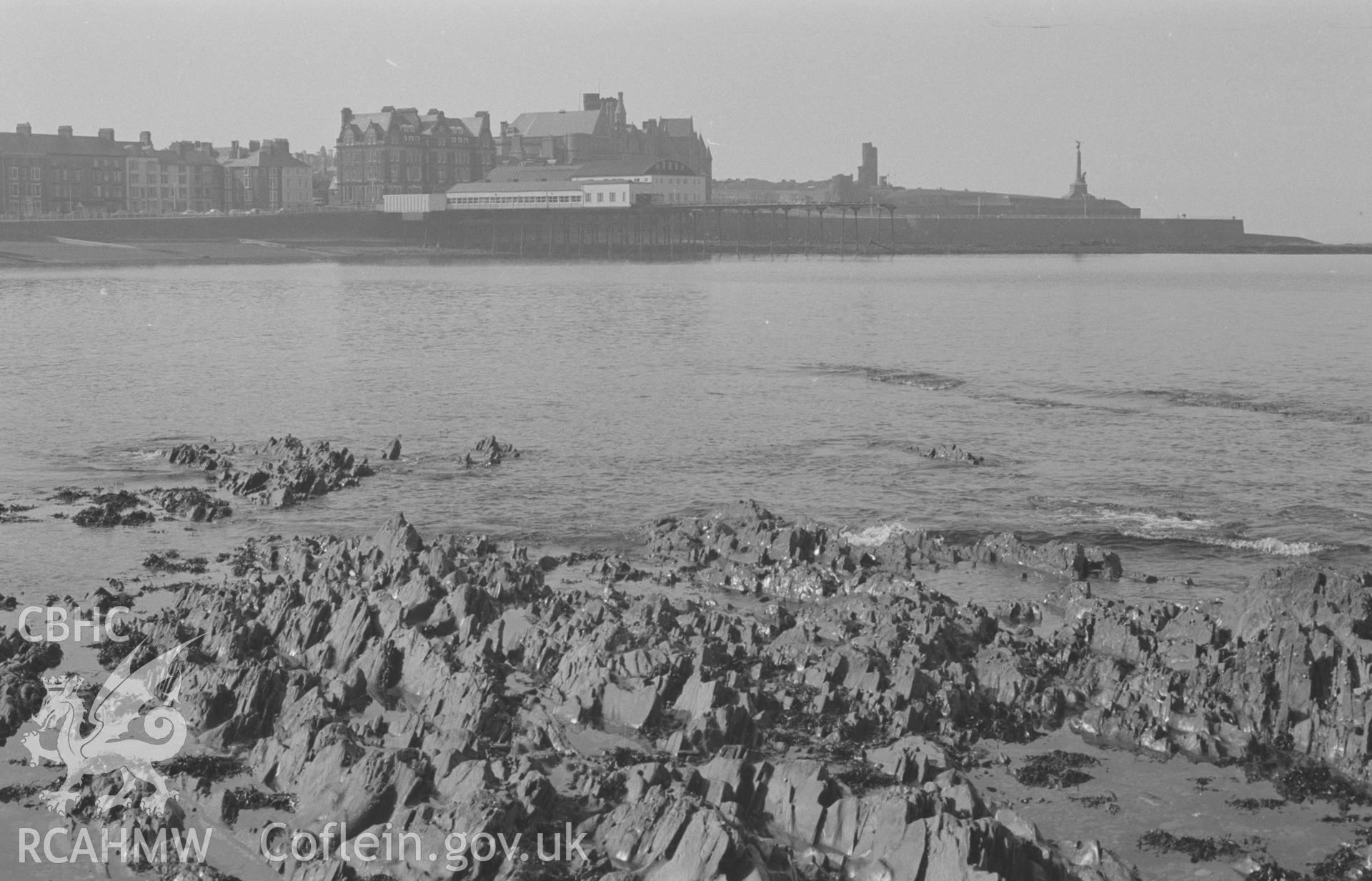 Digital copy of a black and white negative showing the pier, Hotel Cambria, Castle and War Memorial at Aberystwyth. Photographed by Arthur O. Chater on 9th April 1968 looking south south west from rocks opposite Queen's Hotel at Grid Reference SN 583 822.