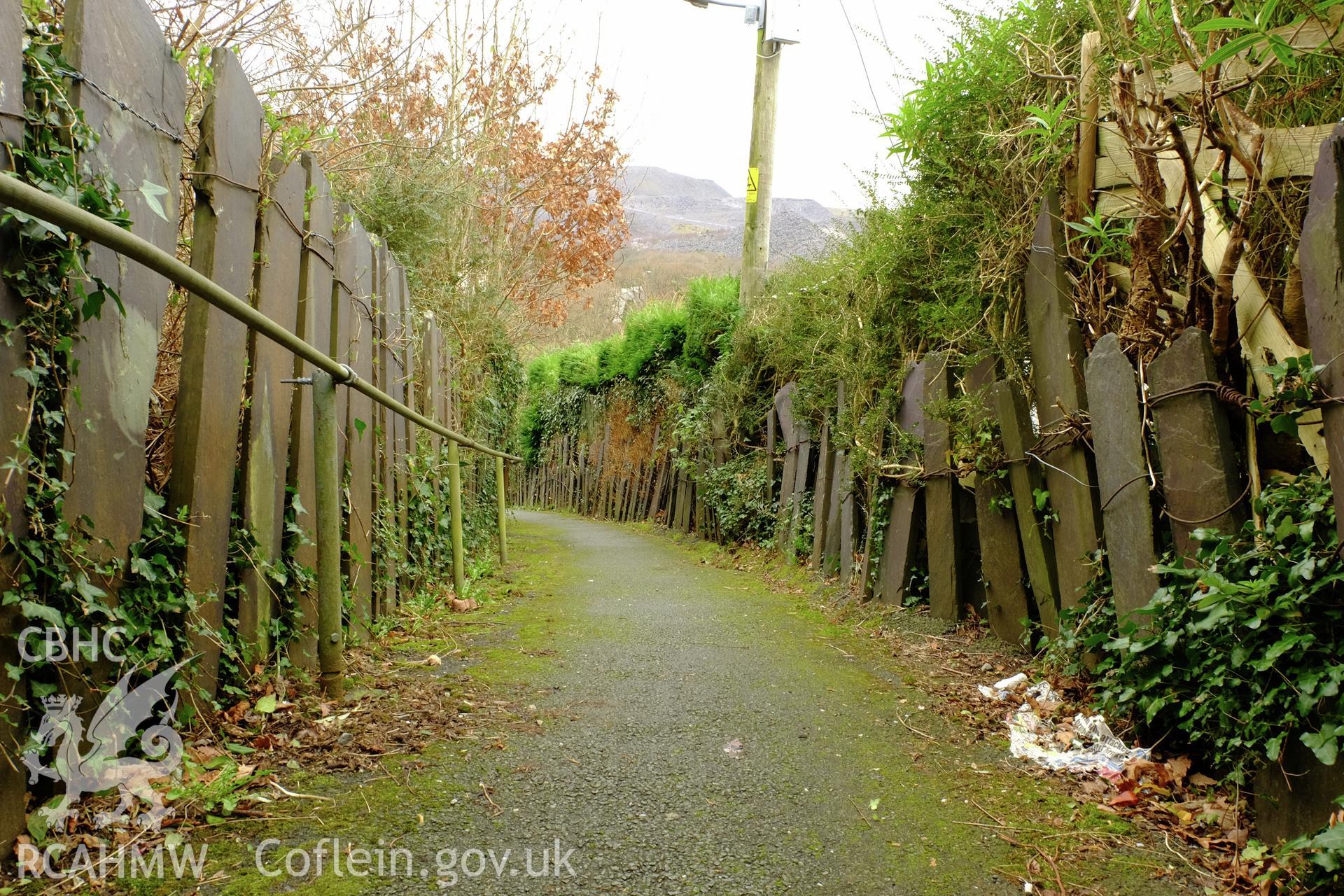 Colour photograph showing view looking south west, showing slate fences on footpath below Well Street, Gerlan, Bethesda, produced by Richard Hayman 16th February 2017