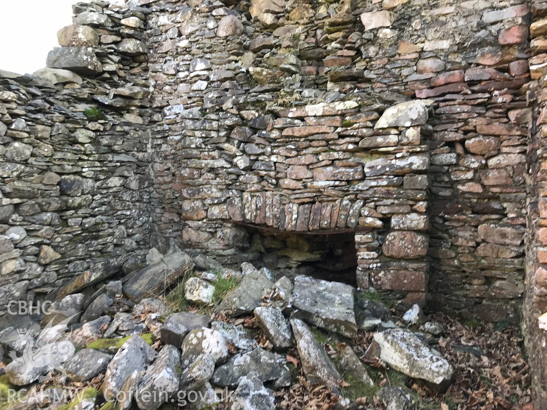 Detailed view of a ruined wall and the remains of a fireplace at Caradog house, south west of Bryneithinog farm, Ystrad Fflur. Colour photograph taken by Paul R. Davis on 18th November 2018.