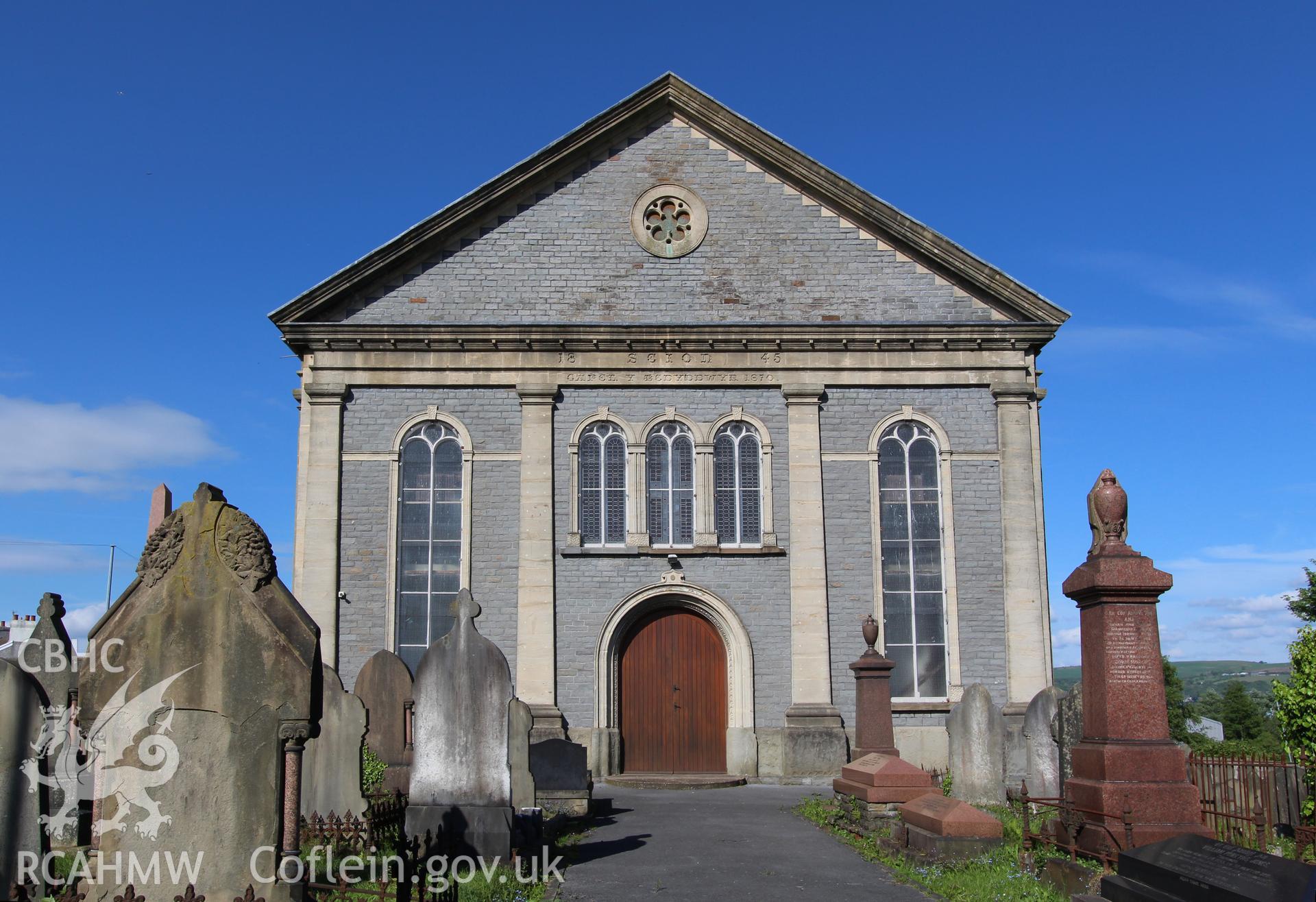 Exterior view of graveyard and chapel's front facade. Inscription beneath tympanum reads: '18 Seion 45/ CAPEL Y BEDYDDWYR 1870. Photographic survey of Seion Welsh Baptist Chapel, Morriston, conducted by Sue Fielding on 13th May 2017.