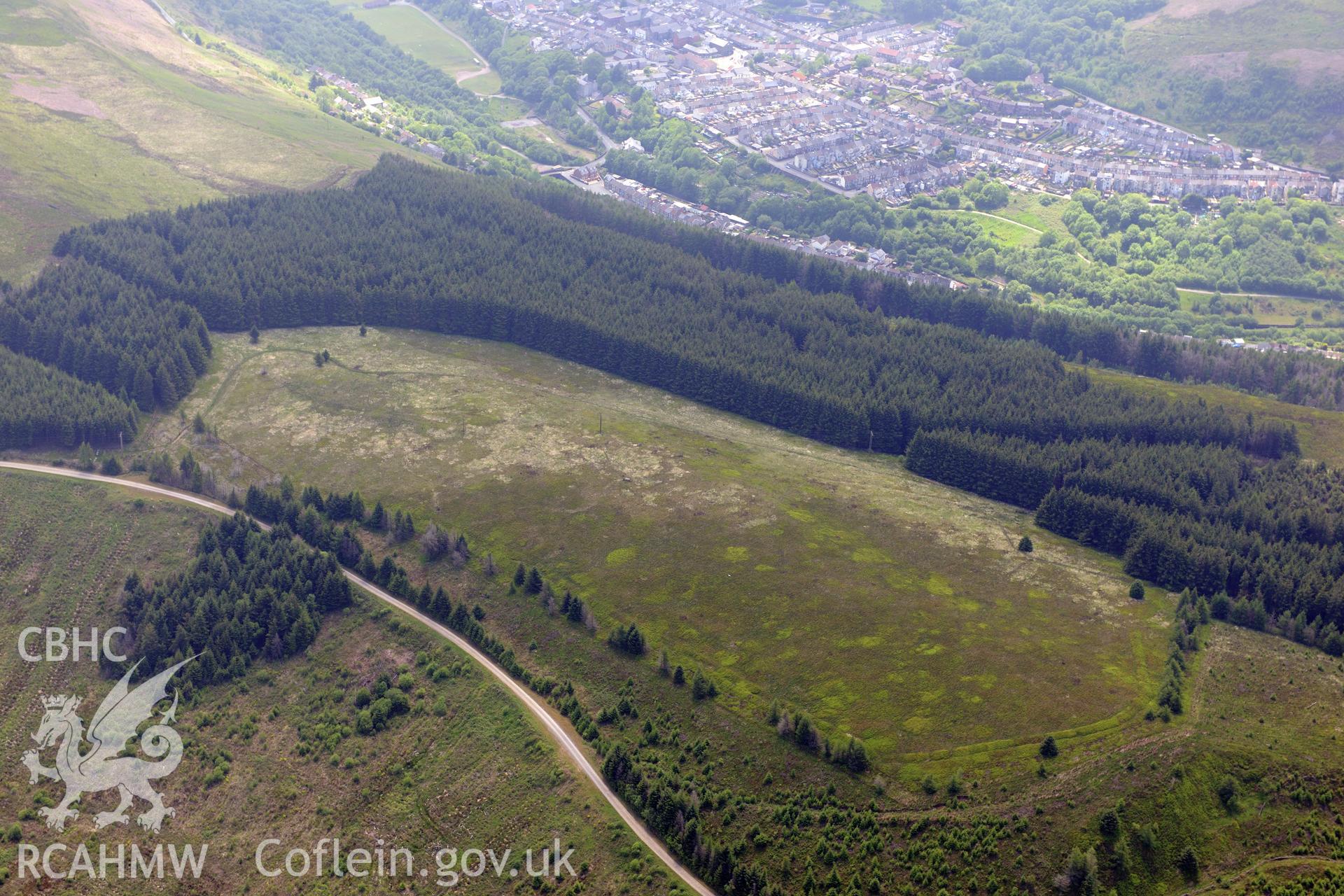 Twyn y Briddallt Roman Camp with the town of Ferndale beyond. Oblique aerial photograph taken during the Royal Commission's programme of archaeological aerial reconnaissance by Toby Driver on 11th June 2015.