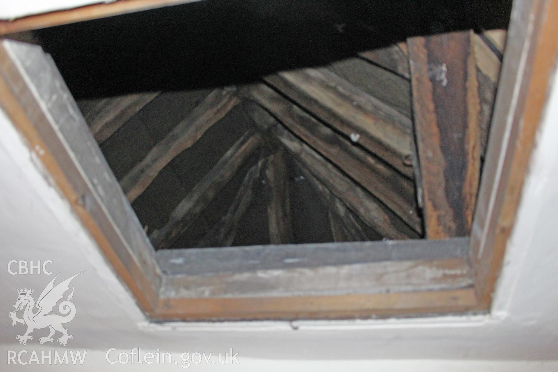Colour photograph showing view looking up through attic door at timber roof frame at Porth y Dwr, Clwyd Street, Ruthin. Photograph taken during survey conducted by Geoff Ward on 9th October 2014.