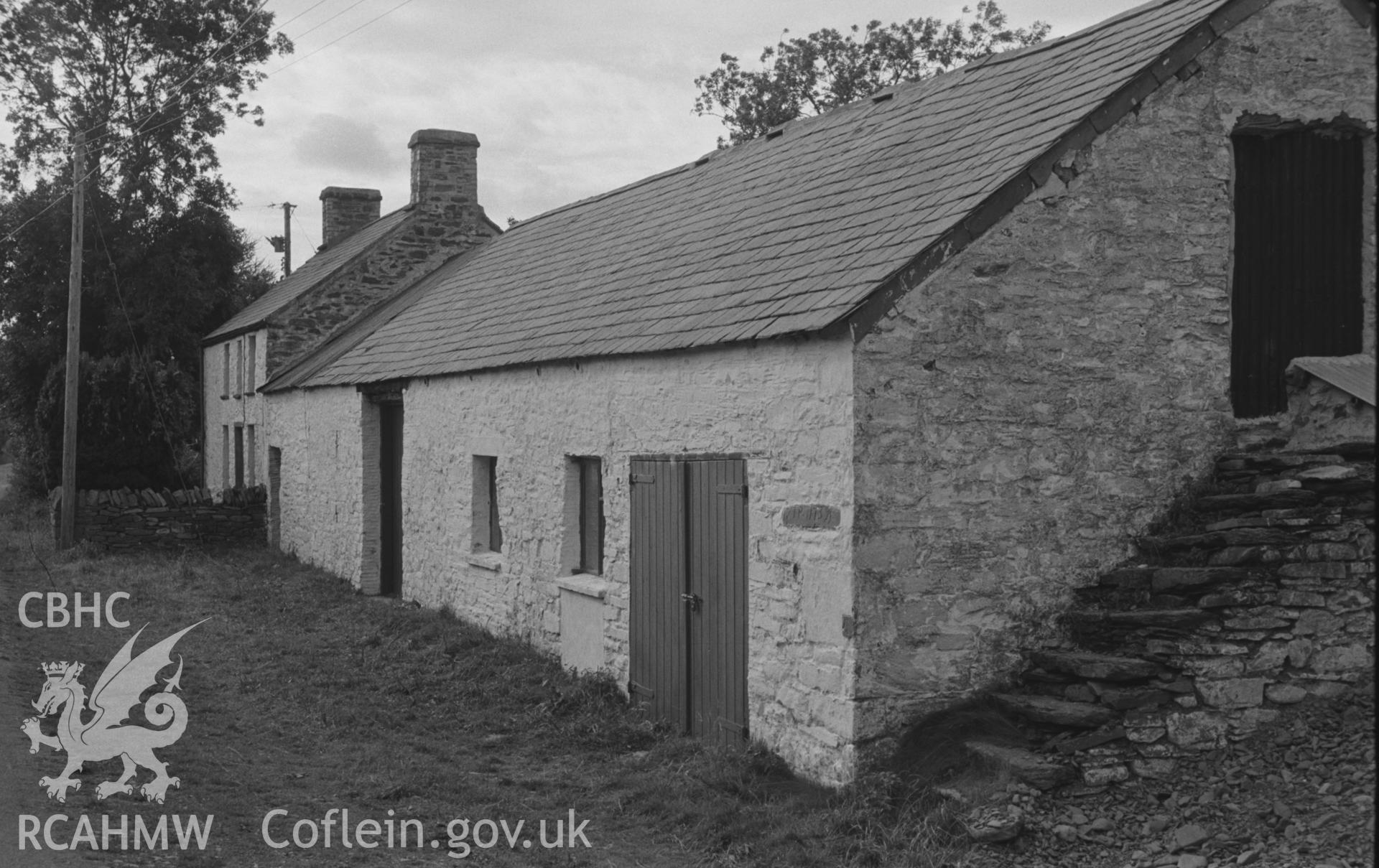 Digital copy of black & white negative looking north west at Lletty-Meurig on north side of road up Cwm Berwyn; stone inscribed 'T R (1739)' is coloured dark on extreme right of outhouse's front wall. Photograph by Arthur Chater, 2/9/1966 from SN 693 593.