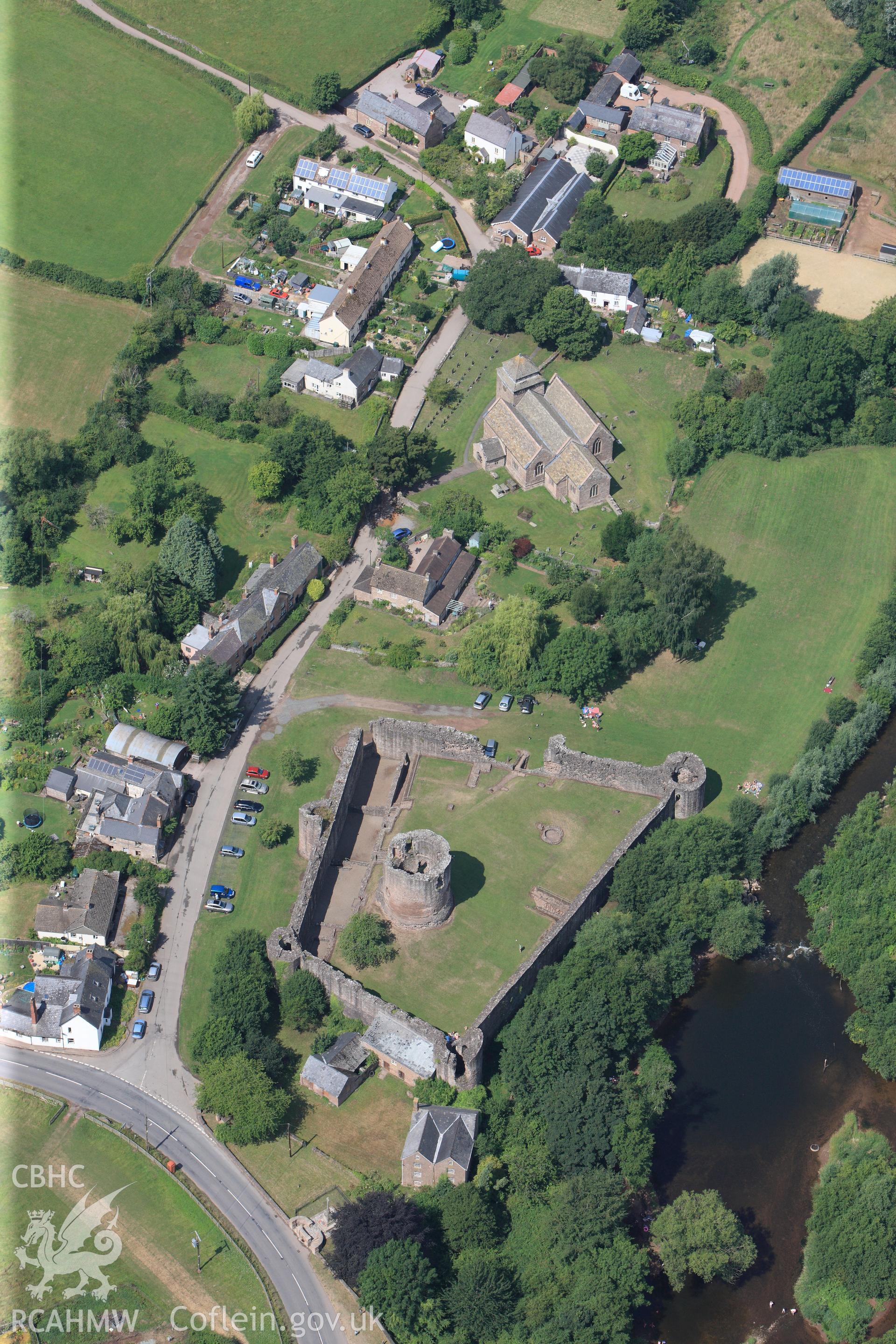 Skenfrith Castle, with Skenfrith corn mill immediately to the south east and St. Bridget's Church to the north west, Skenfrith, Monmouth. Oblique aerial photograph taken during Royal Commission?s programme of archaeological aerial reconnaissance by Toby Driver on 1st August 2013.