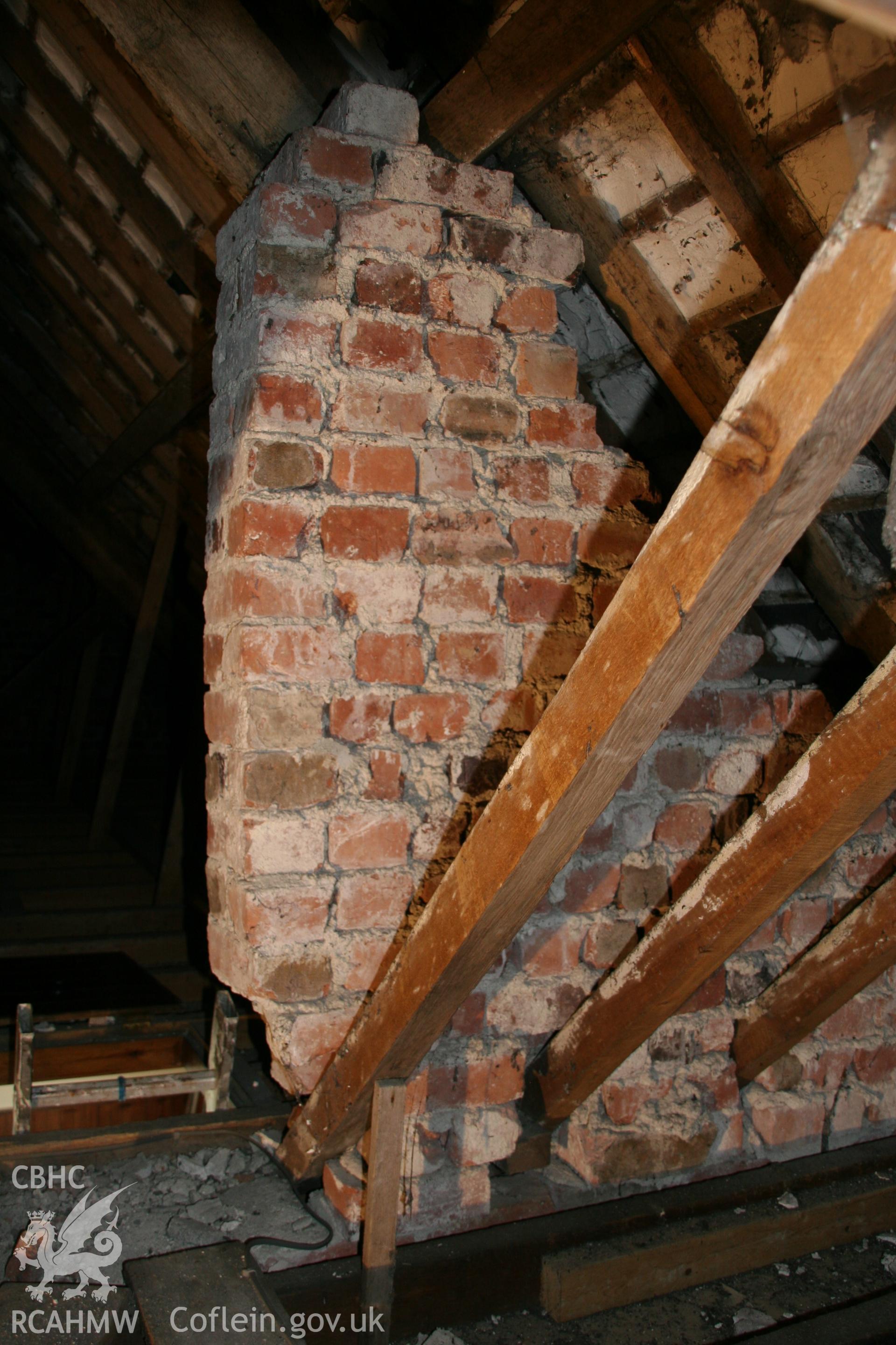 Photograph showing interior view of wooden beams, floor boards & brick wall in loft of former Llawrybettws Welsh Calvinistic Methodist chapel, Glanyrafon, Corwen. Taken by Tim Allen on 27/02/2019 to meet a condition attached to planning application.